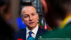 Micheál Martin, Ireland's deputy PM and foreign minister, is seen between two people as he talks to the press at an EU summit in Brussels, Belgium, 15 December 2022