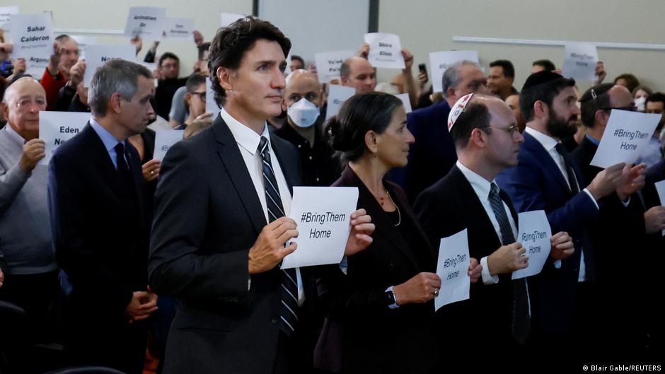 Canada's Prime Minister Justin Trudeau holds up a sign with attendees during a pro-Israel rally