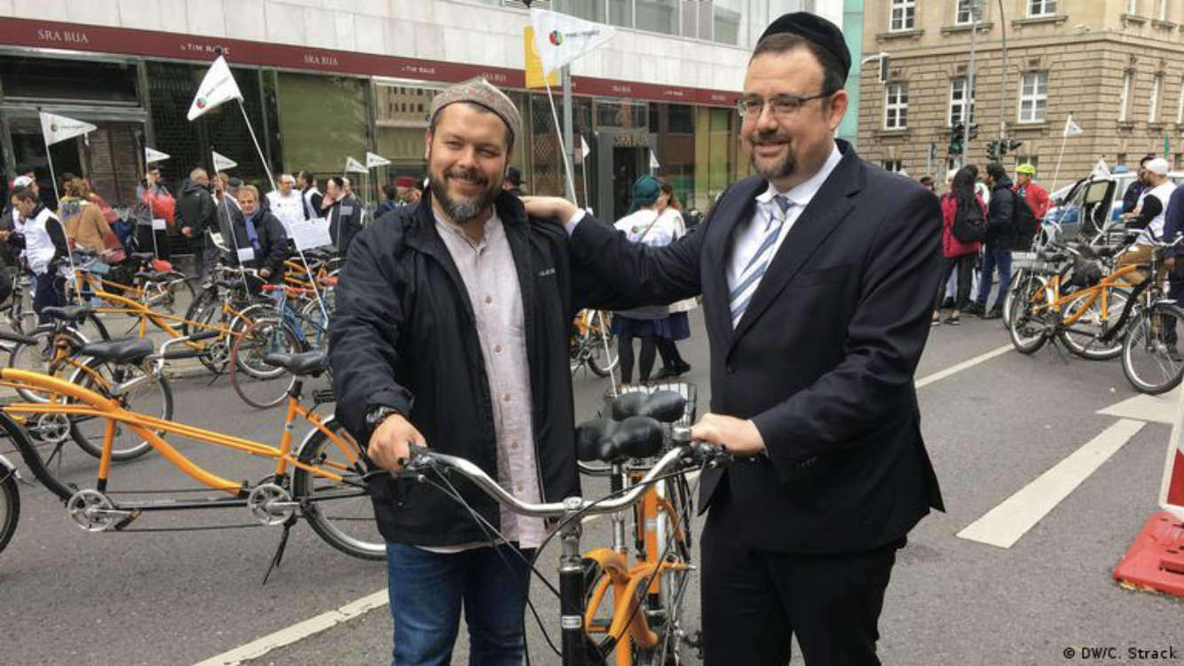 Imam Ender Cetin (left) and Rabbi Elias Dray on a tandem bike tour of Berlin in 2018