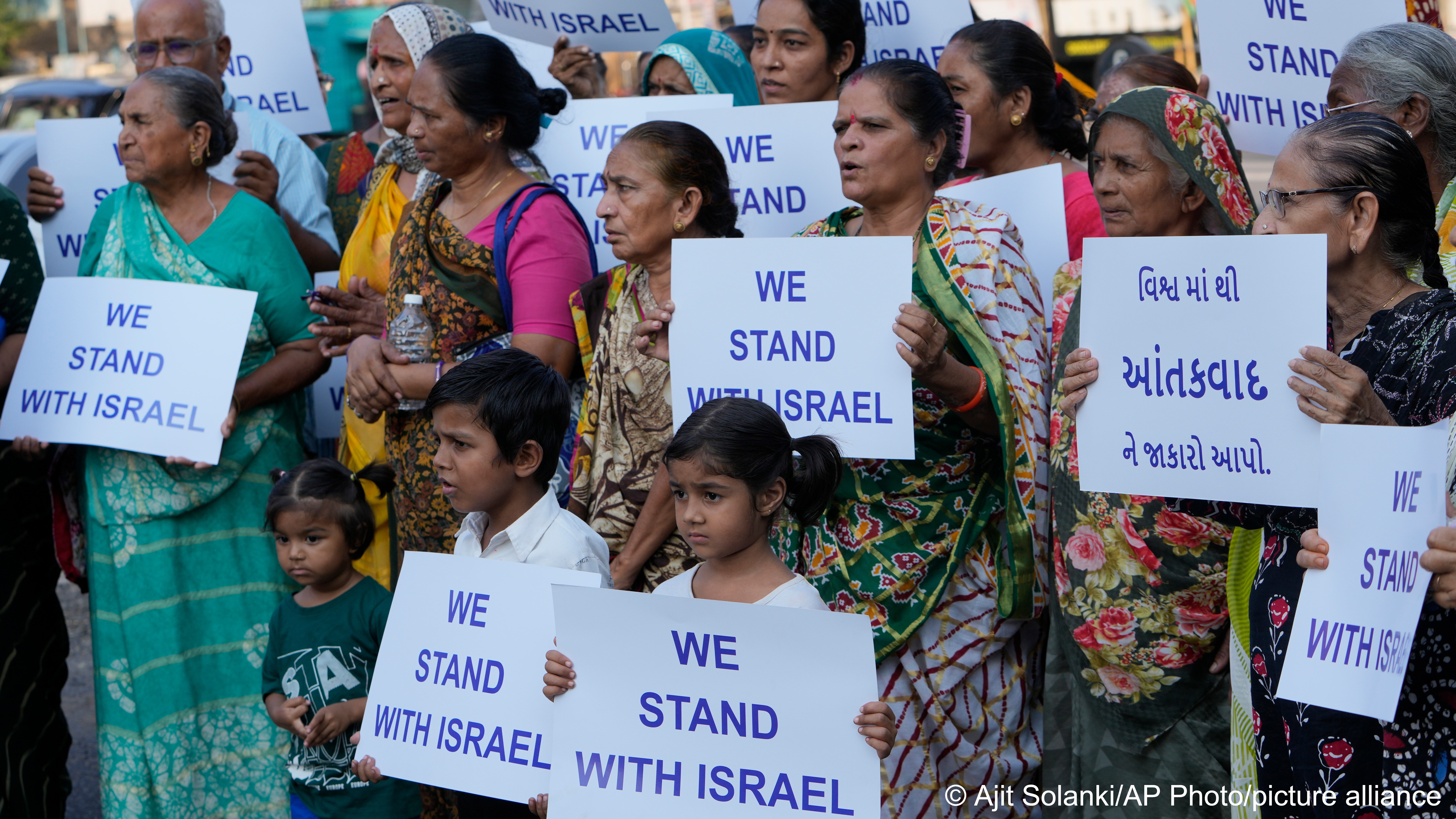 People in Ahmedabad hold placards bearing the message "We stand with Israel"