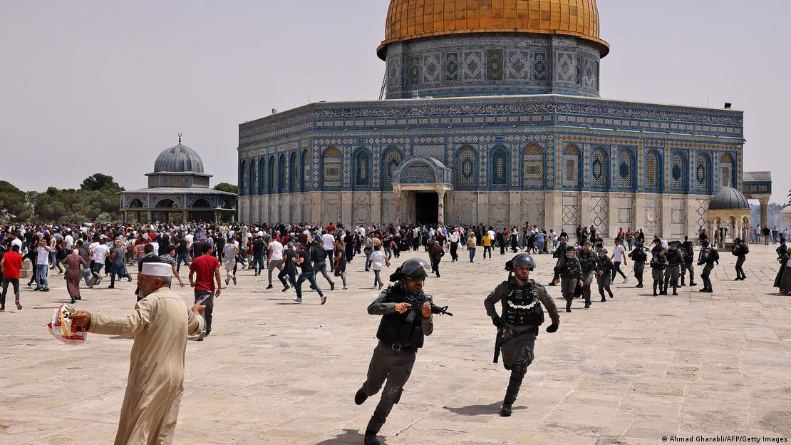 Young men run across the plaza in front of Al-Aqsa mosque in Jerusalem