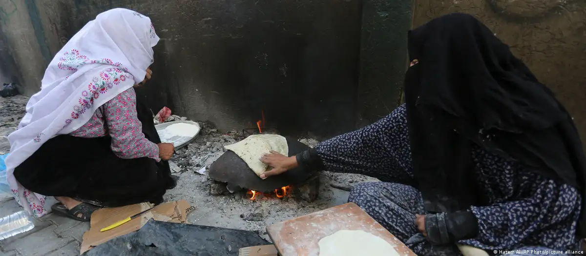 امرأتان فلسطينيتان تخبزان الخبز في رفح بقطاع غزة. (Foto: Hatem Ali/AP Photo/picture alliance) wei palästinensische Frauen backen Brot in Rafah im Gazastreifen.