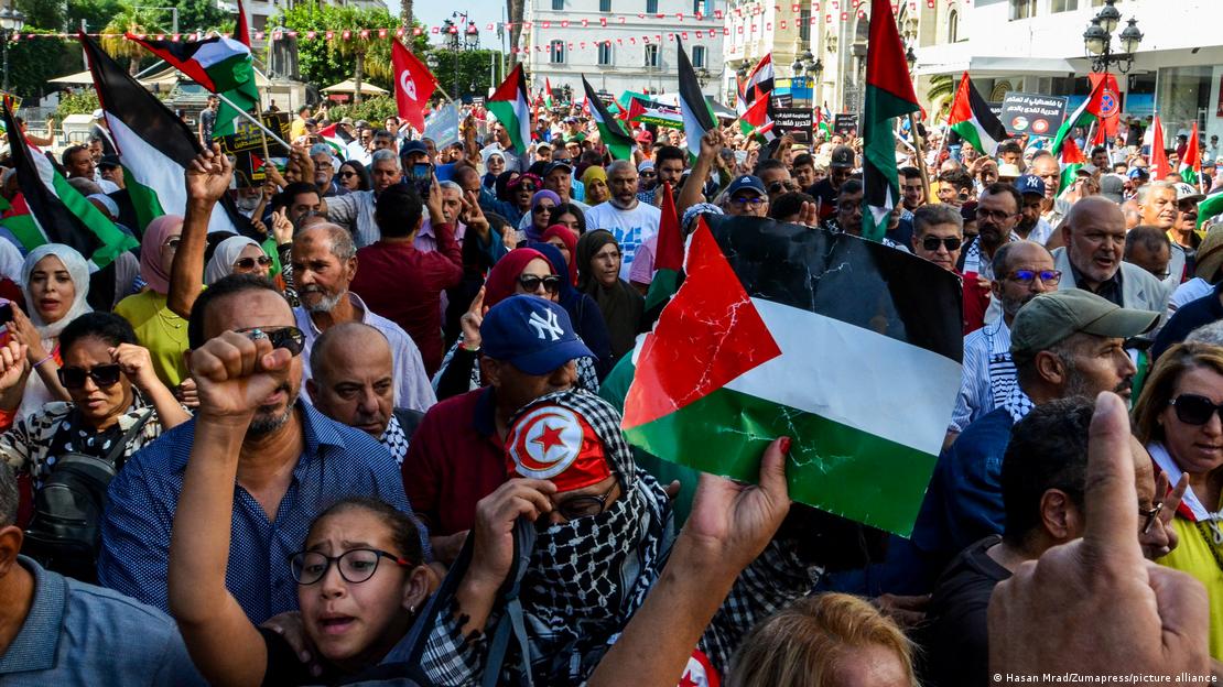 A crowd of people wave Tunisian but mostly Palestinian flags and chant slogans as they walk down a street during a pro-Palestinian demonstration in Tunis, Tunisia, 15 October 2023