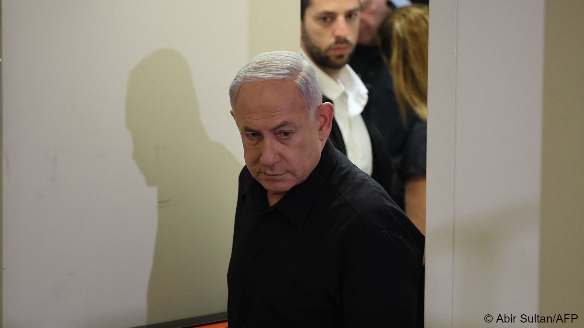 Israel's Prime Minister Benjamin Netanyahu enters a room in a black shirt