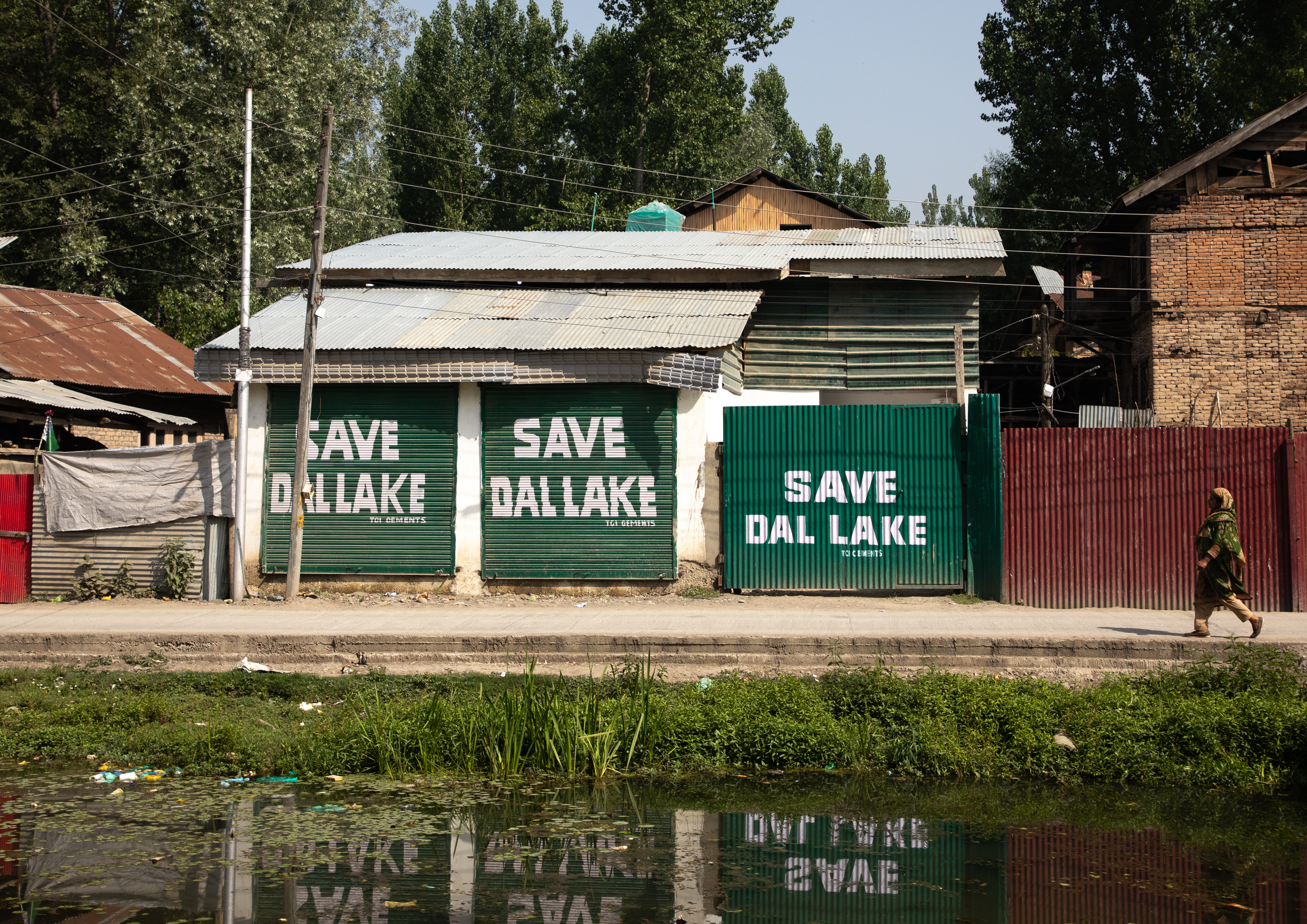 Graffiti on the exterior wall of a building appeals for people to "Save Dal Lake"