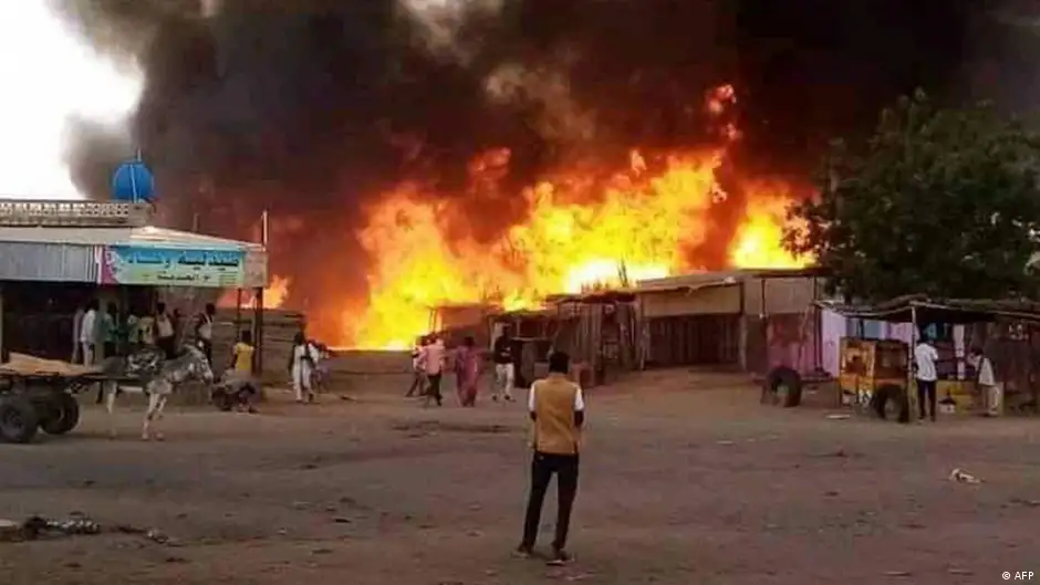 Man watches as fire rages in the market area of al-Fasher, capital of North Darfur state