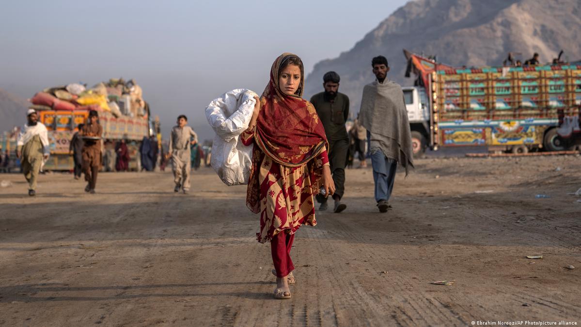 An Afghan refugee girl collects rubbish in a camp near the Pakistan-Afghanistan border in Torkham
