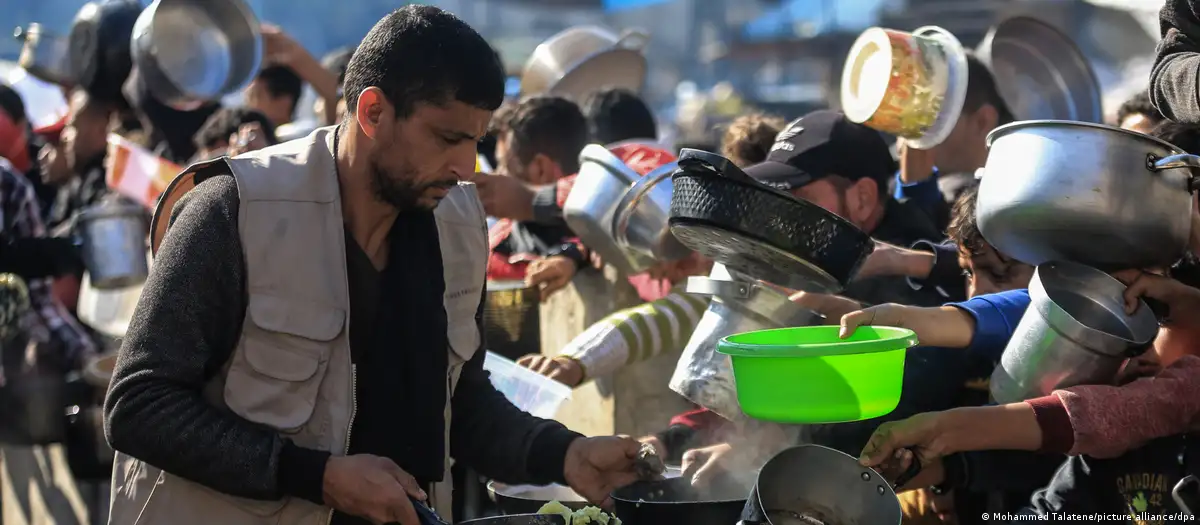 Ein Helfer einer Wohltätigkeitsorganisation im Gazastreifen versorgt Hunderte hungrige Menschen mit einer warmen Mahlzeit.