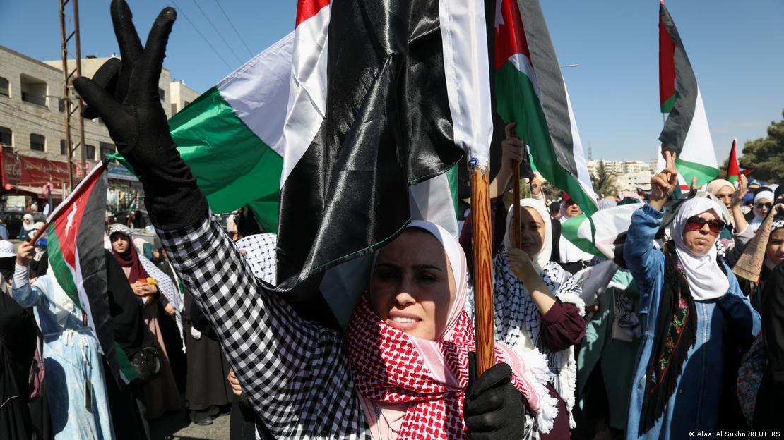 صورة من: Alaal Al Sukhni/REUTERS - أردنيون محتجون أمام السفارتين الإسرائيلية والأمريكية في عَمَّان ضد الحرب الانتقامية الإسرائيلية في قطاع غزة.  Jordanier protestieren vor der israelischen und amerikanischen Botschaft in Amman