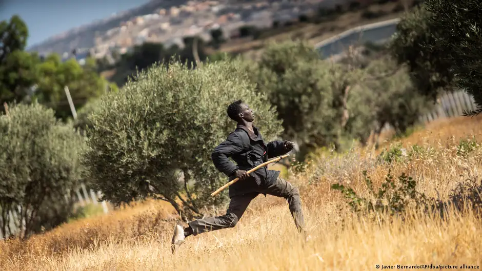 A migrant runs across a field in the Spanish enclave of Melilla