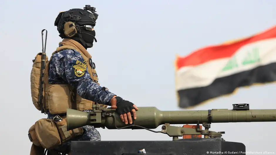 A soldier takes part in a military parade held at the police academy in Baghdad. An Iraqi flag is seen in the background