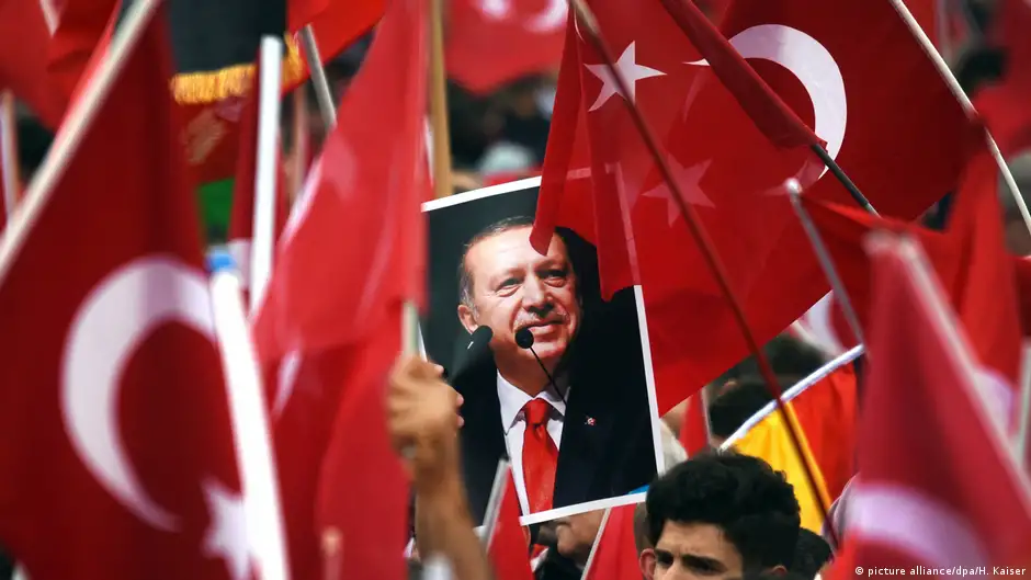 Supporters of Turkish President Recep Tayyip Erdogan hold Turkish flags and his picture