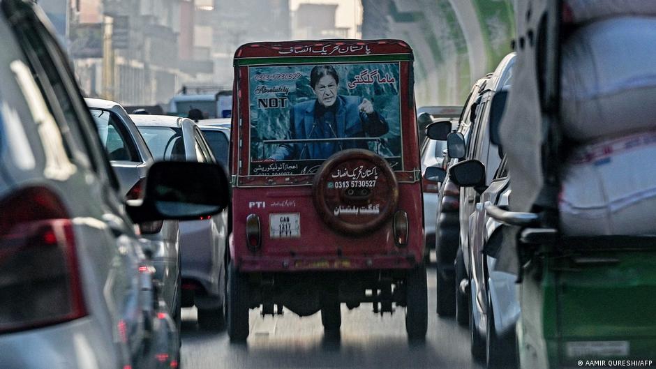 A poster of Pakistan's jailed former premier Imran Khan is displayed behind an auto-rickshaw in Rawalpindi
