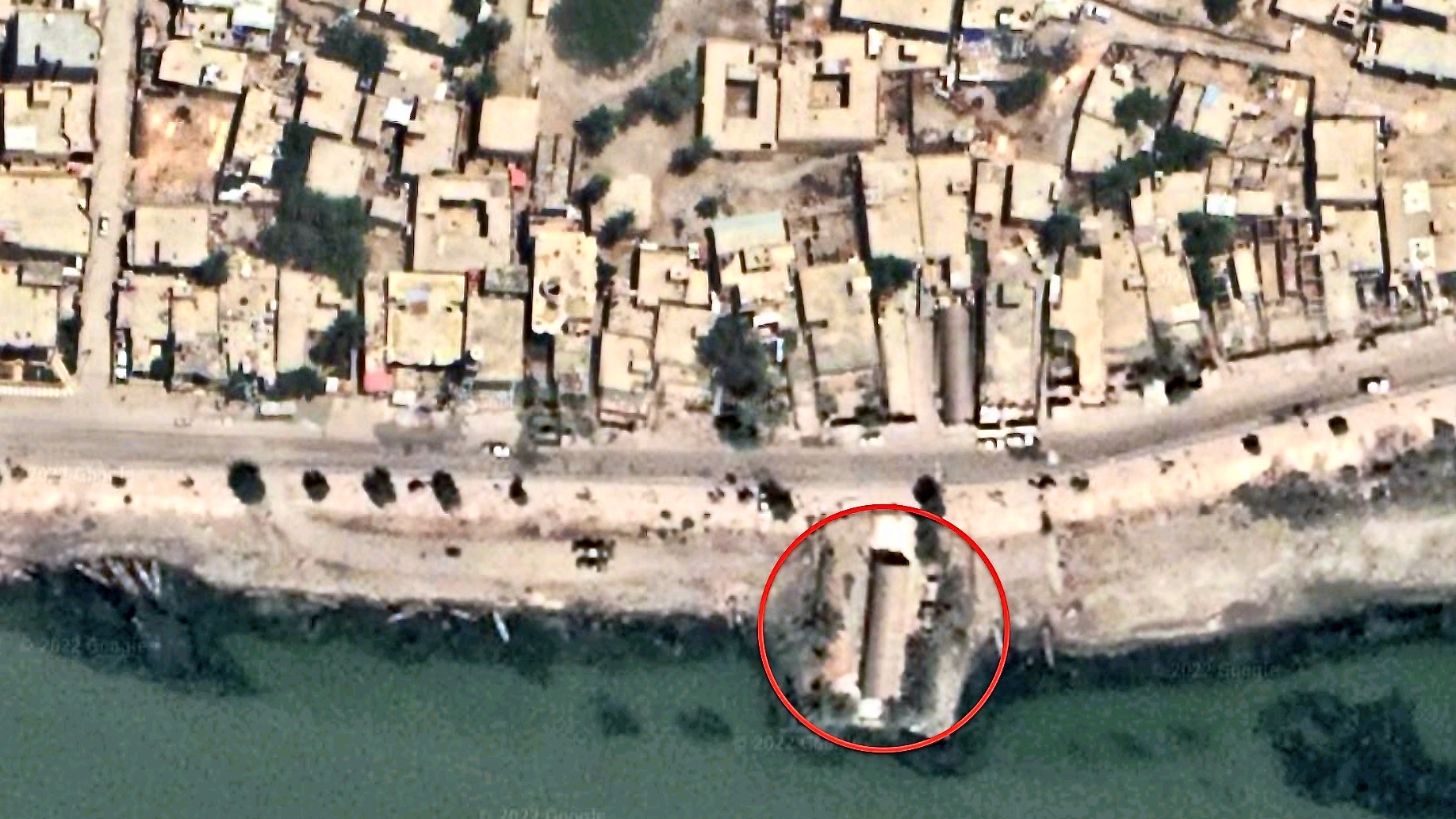 Aerial view by Google Maps showing the outline of a mudhif from above, circled in red