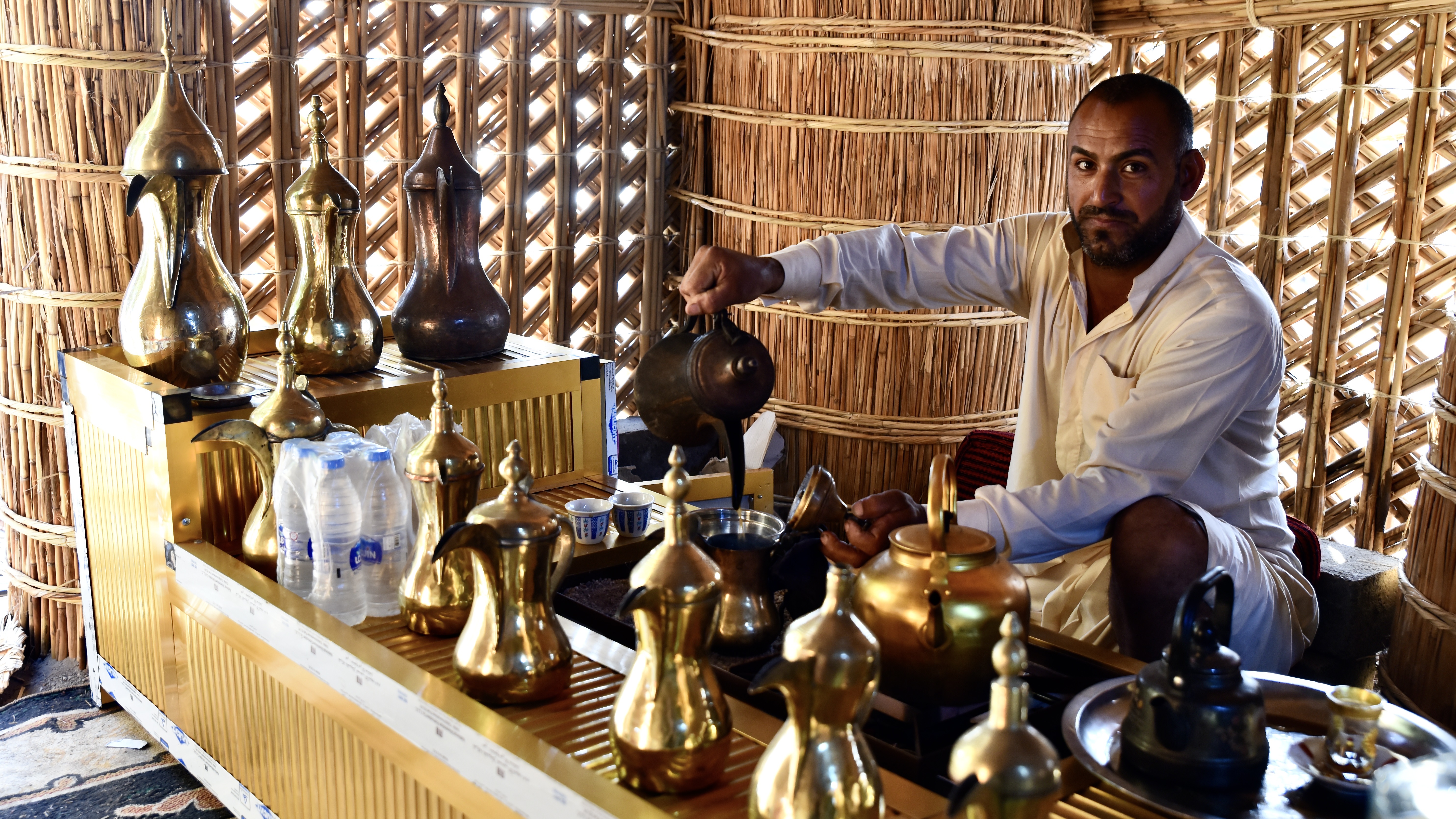 A man pours traditional coffee inside the newly built mudhif