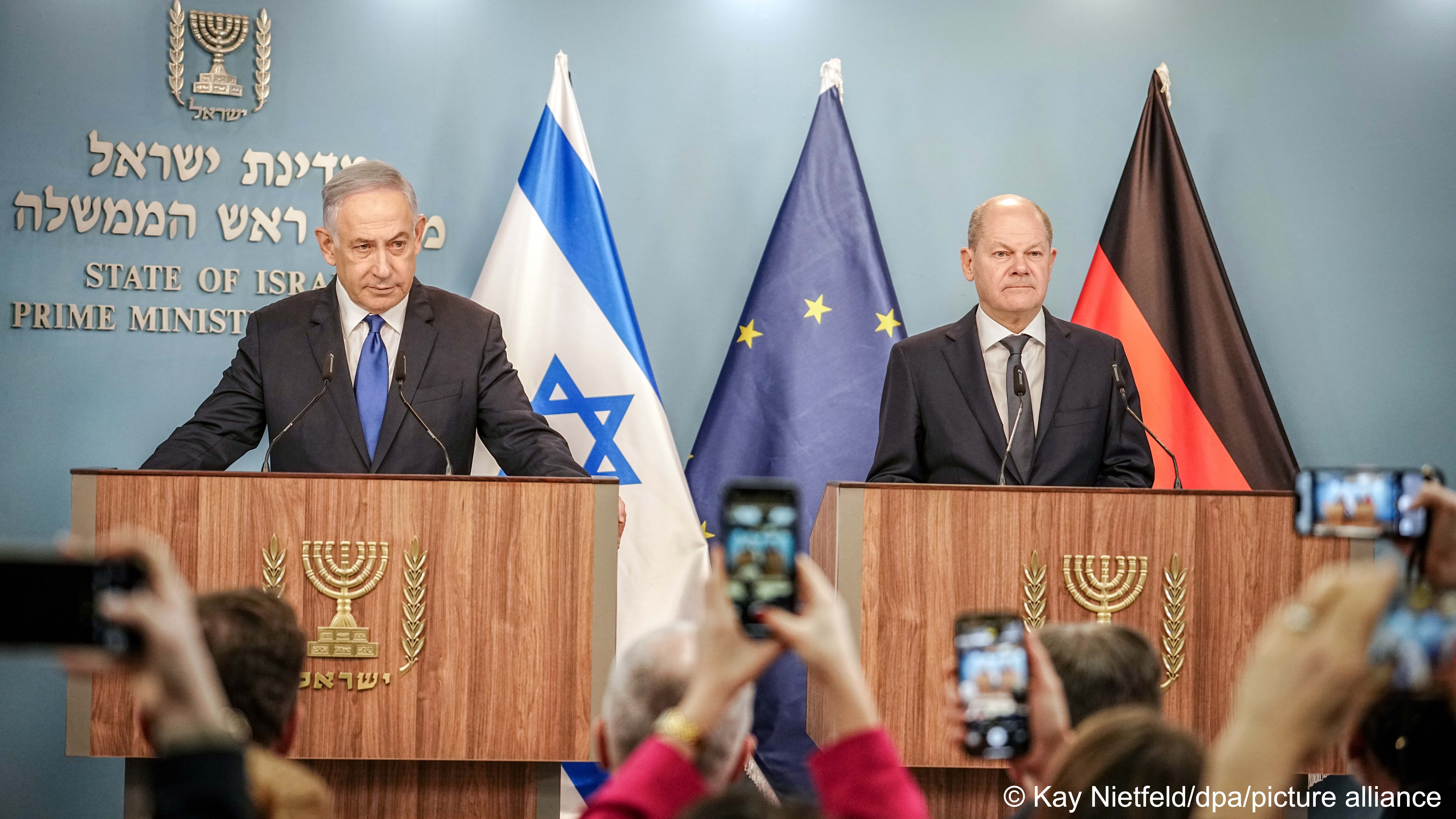 Israeli Prime Minister Benjamin Netanyahu (left) and German Chancellor Olaf Scholz (right) stand at lecterns in front of the flags of Israel, the EU and Germany, Israel, March 2024
