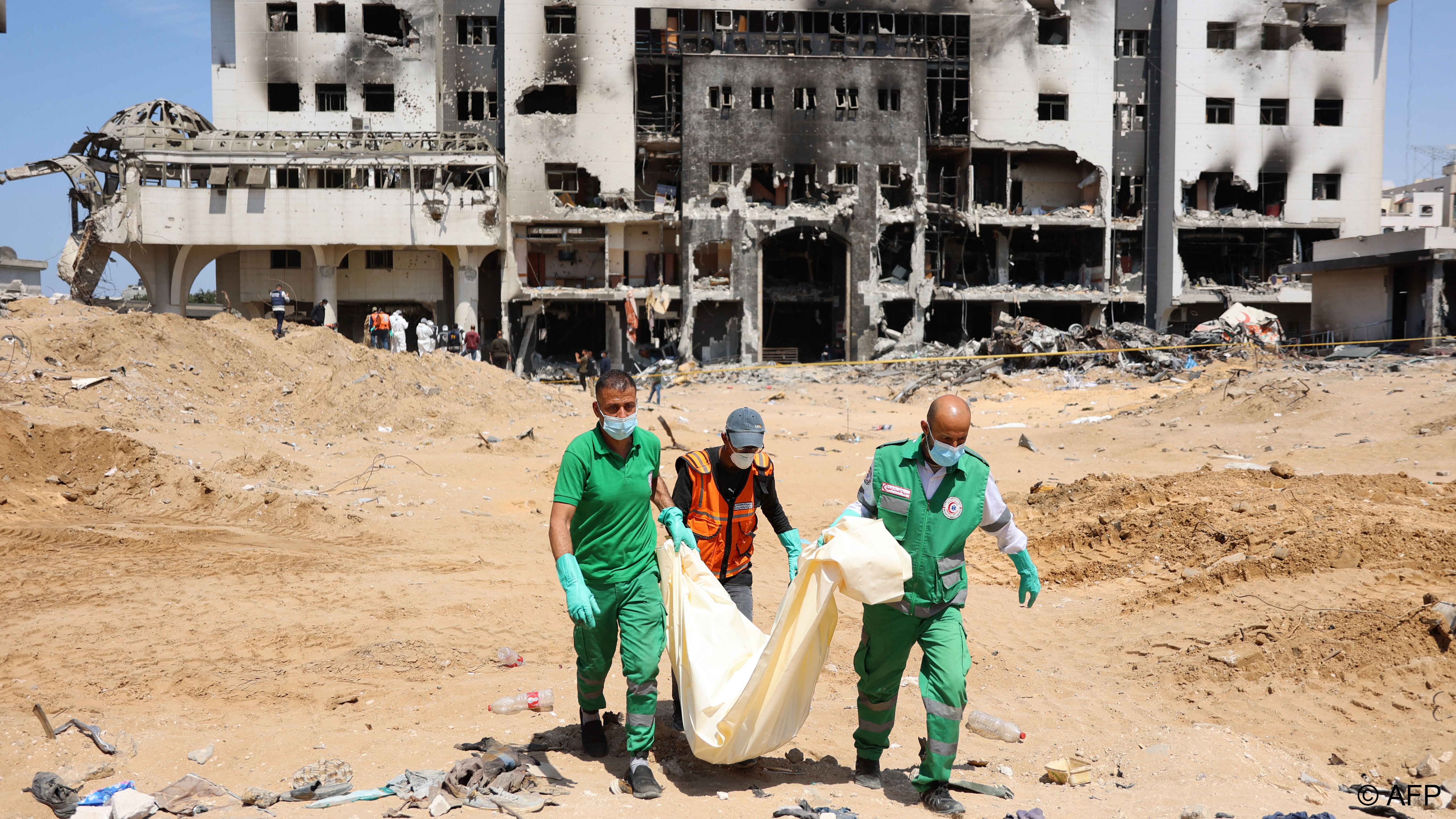 Palestinian civil defence staff recover human remains in the grounds of Gaza's Al-Shifa hospital, which was largely destroyed during an army raid that Israel said targeted hundreds of militants holed up inside