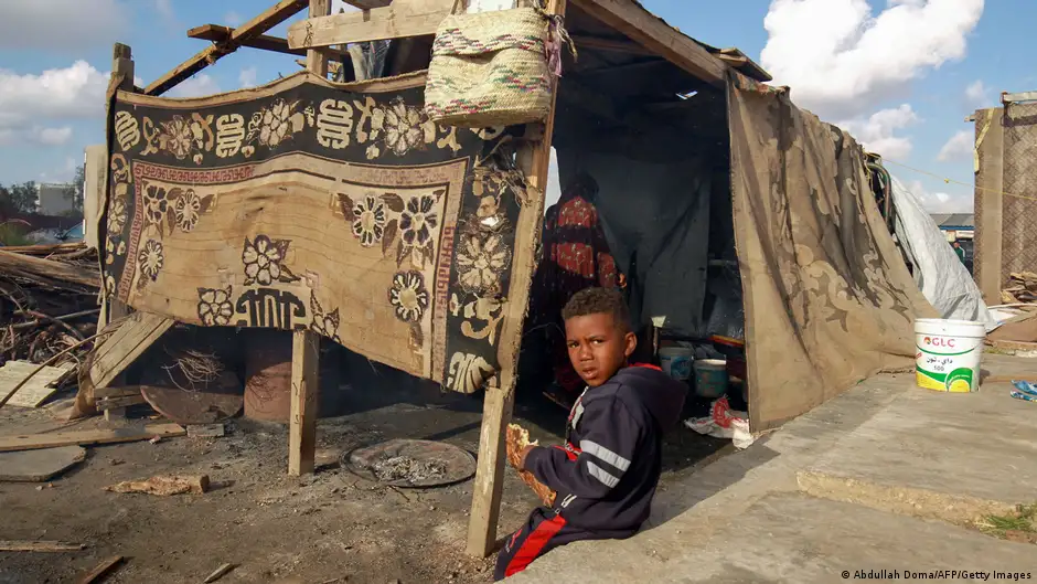 A boy eats freshly-baked Tenor bread at a camp for displaced people in Libya
