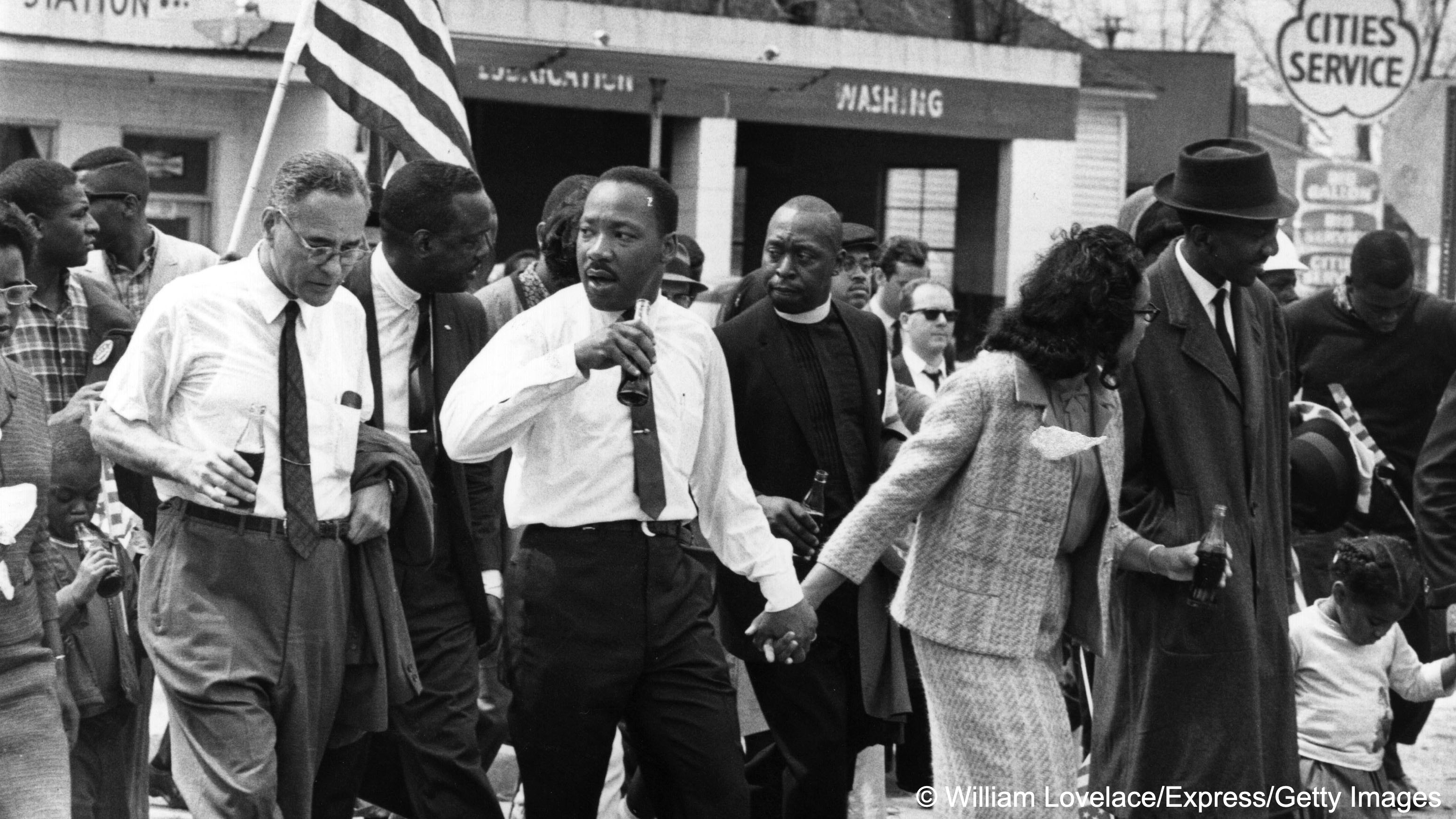 Martin Luther King (centre, holding a bottle and his wife's hand) and his wife Coretta Scott King lead a civil rights march from Selma, Alabama, to the state capital in Montgomery in 1965