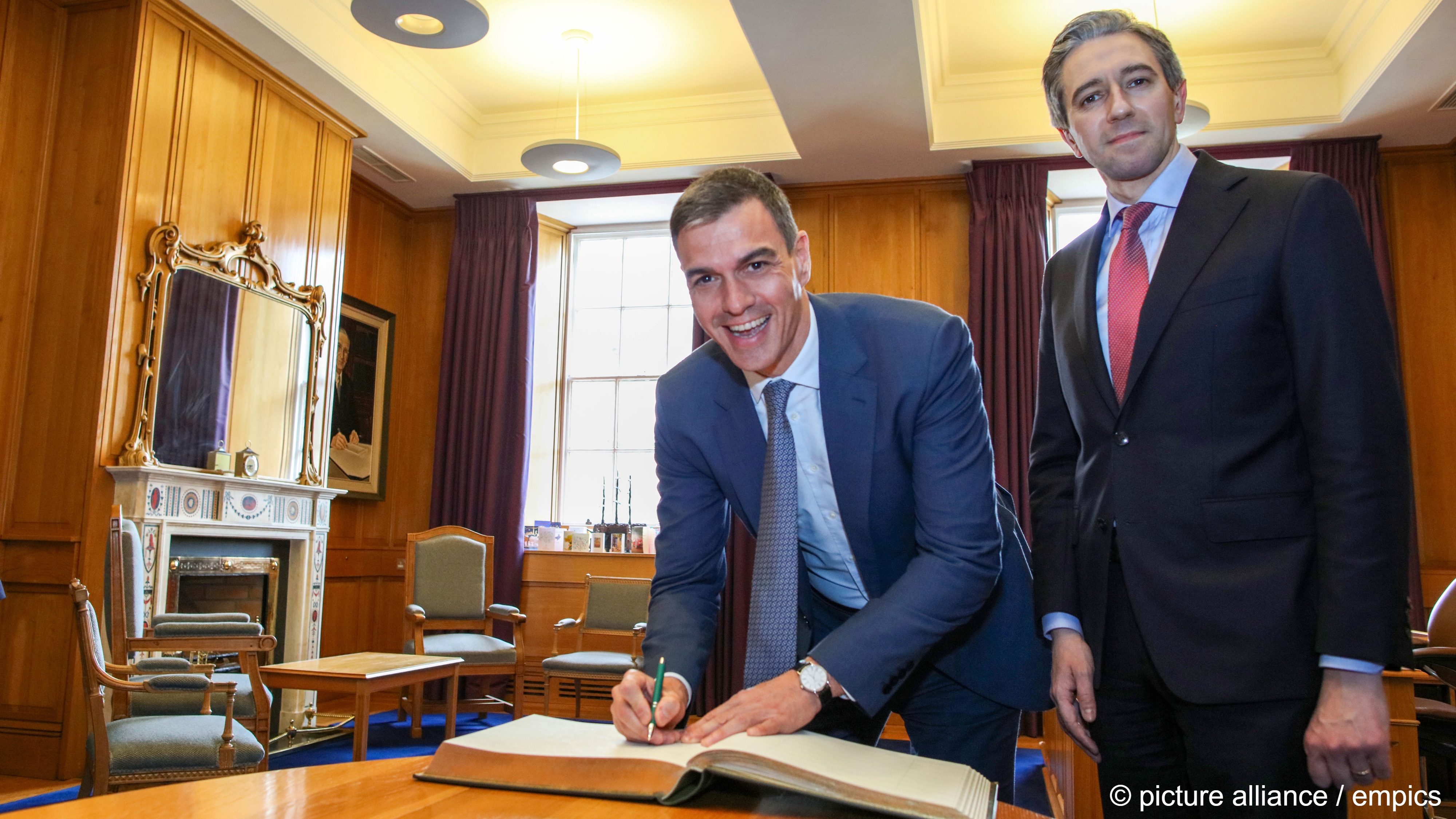Spanish Prime Minister Pedro Sánchez (left) smiles broadly as he signs the visitors' book alongside Irish Prime Minister Simon Harris, Government Buildings, Dublin, Ireland, 12 April 2024
