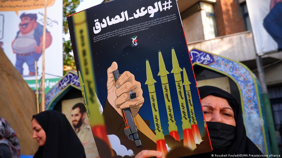 An Iranian pro-government supporter woman holds an anti-Israel poster on Palestine Street in downtown Tehran on 14 April 2024
