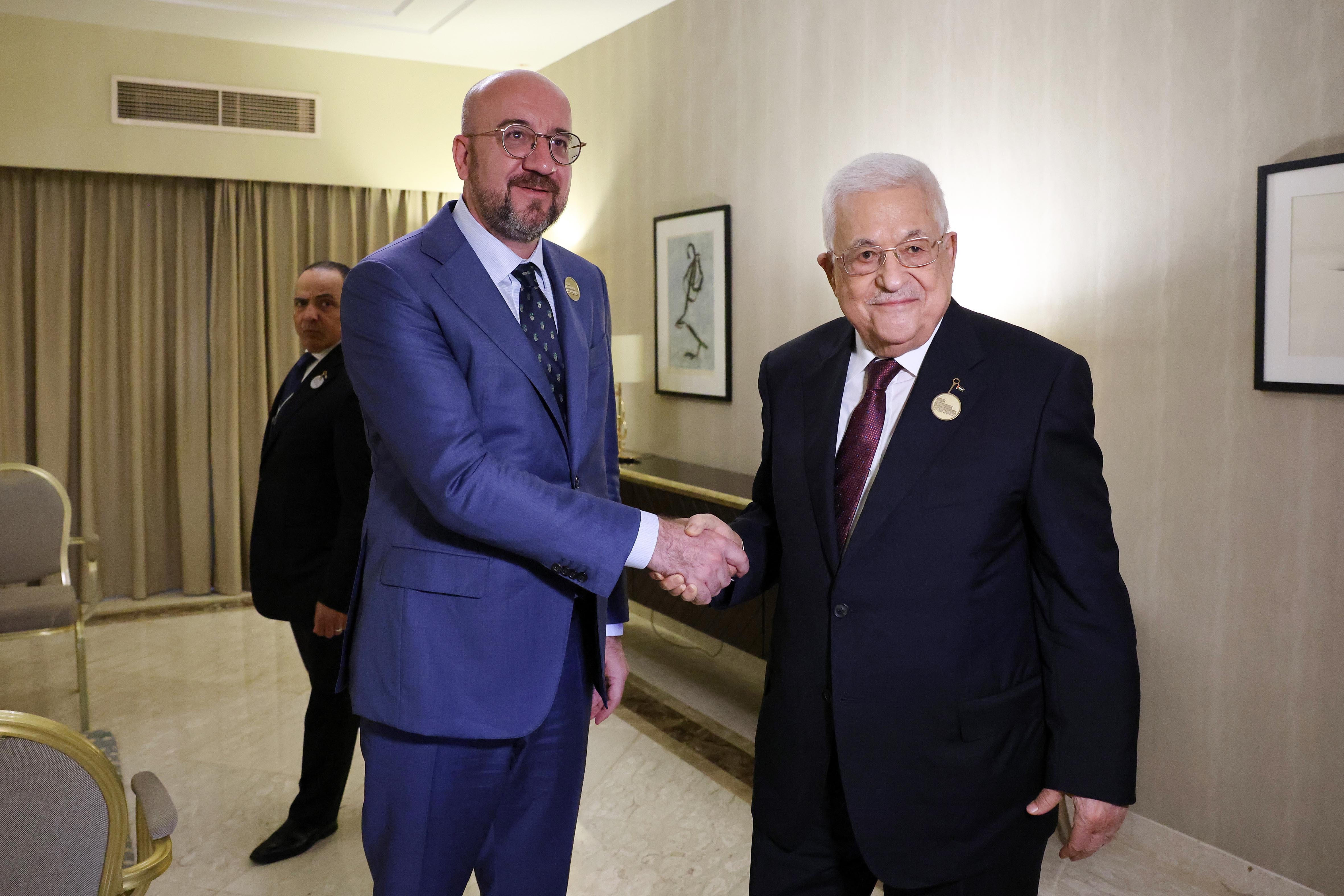 Charles Michel and Mahmoud Abbas shake hands at a meeting.