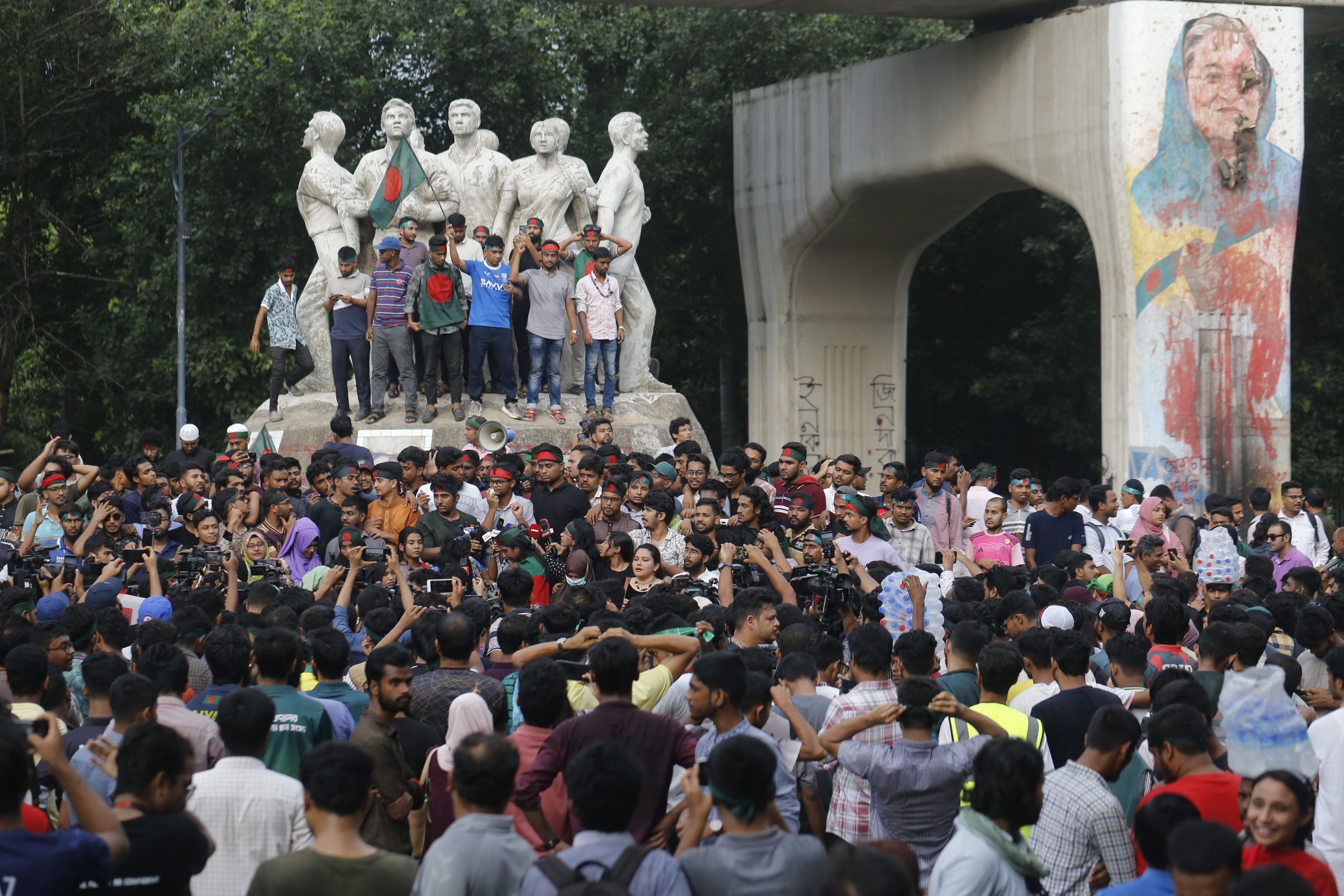 Students demonstrate in Dhaka, Bangladesh, around a monument