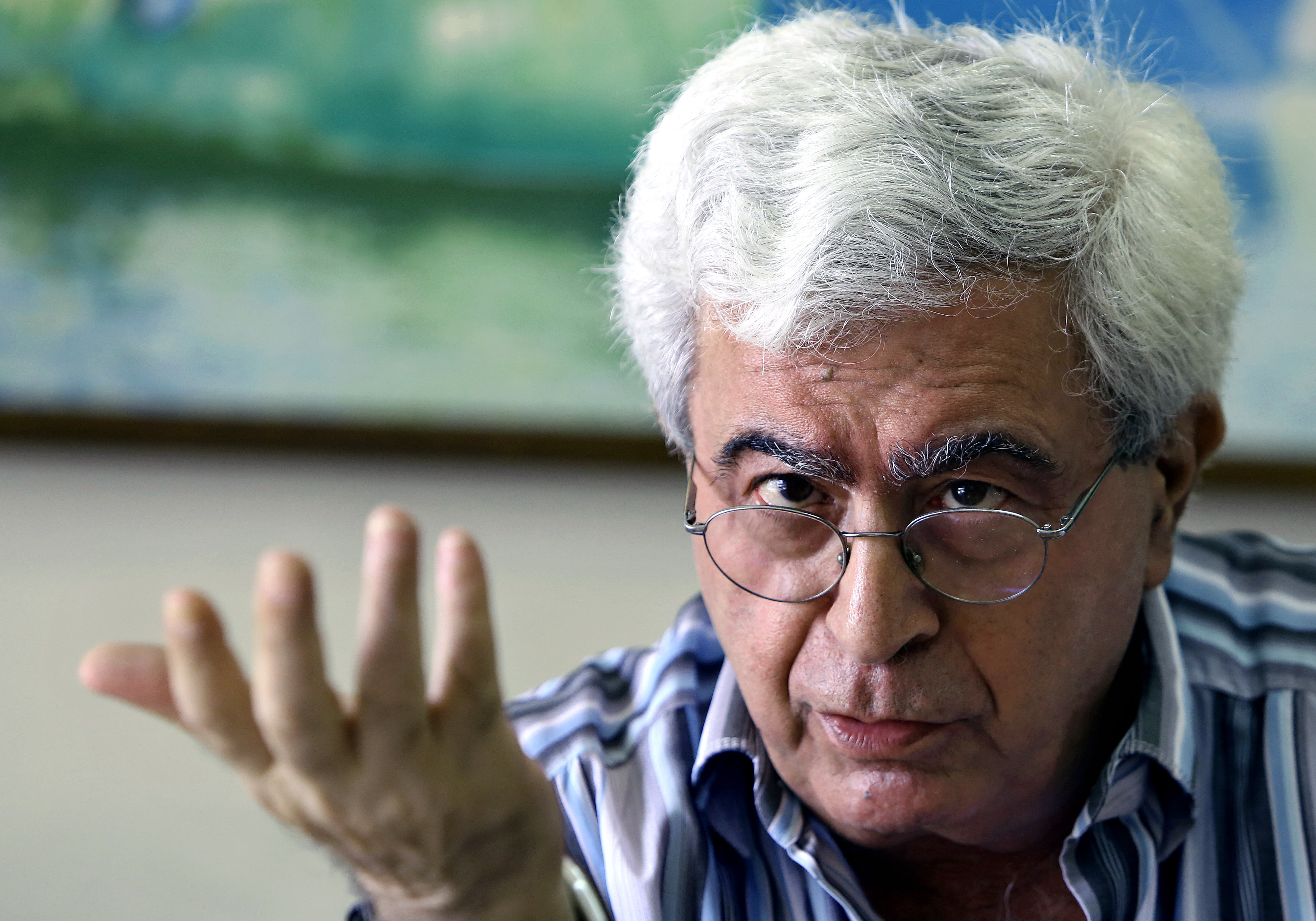 Elias Khoury close up, talking with one hand raised and pointing to the listener.