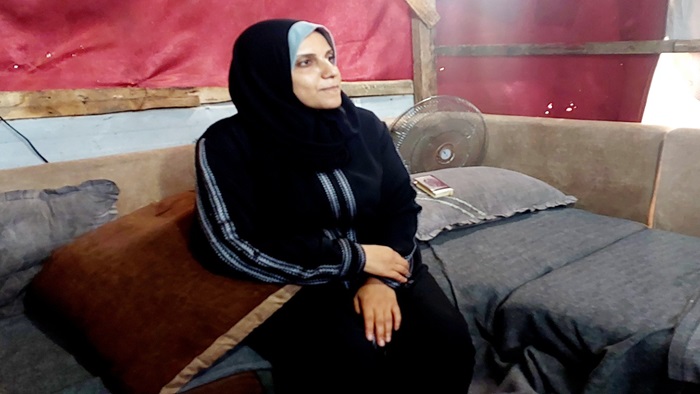 Eine Palästinenserin im Hijab sitzt auf dem Sofa in Gaza