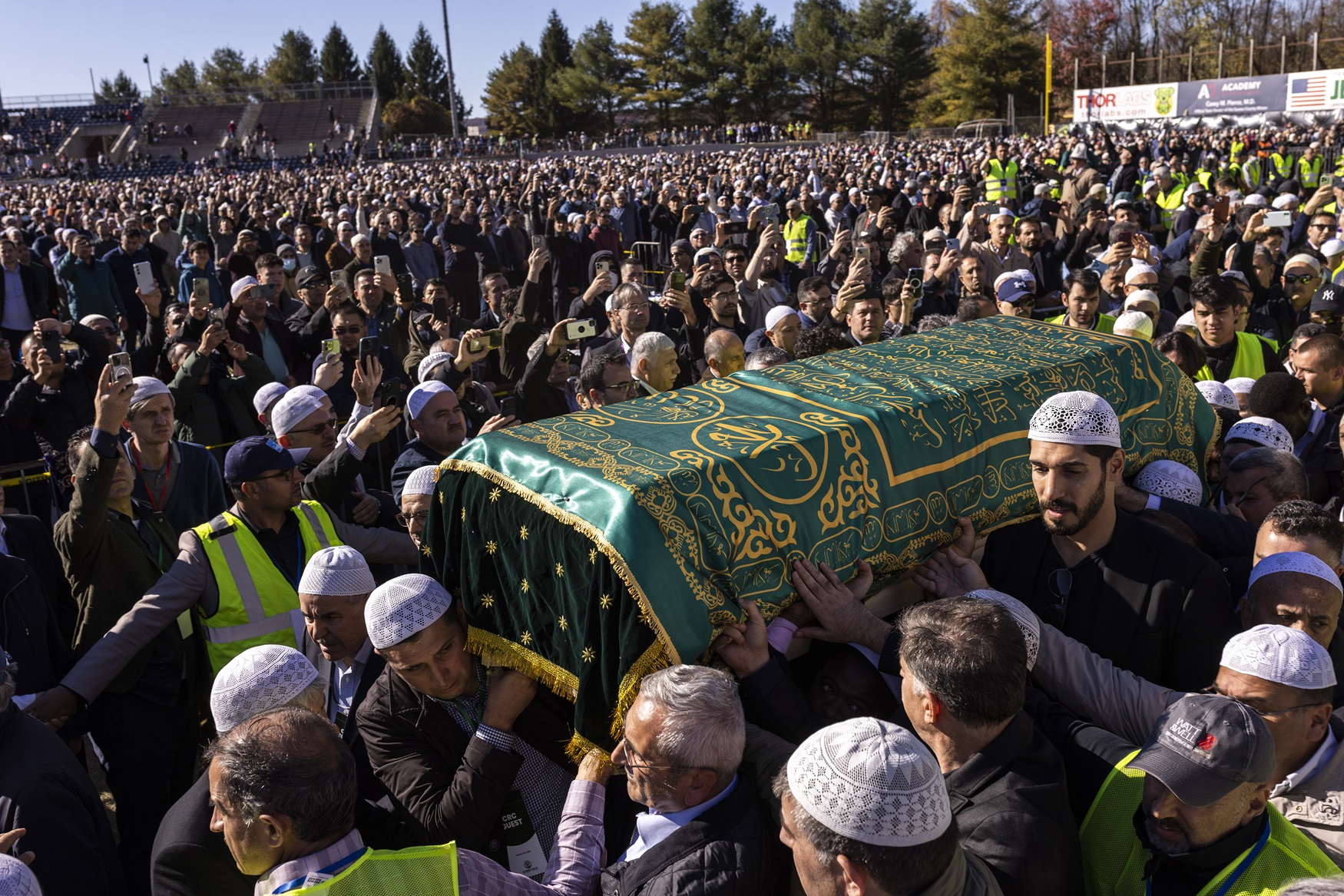 A large crowd carrying a casket.