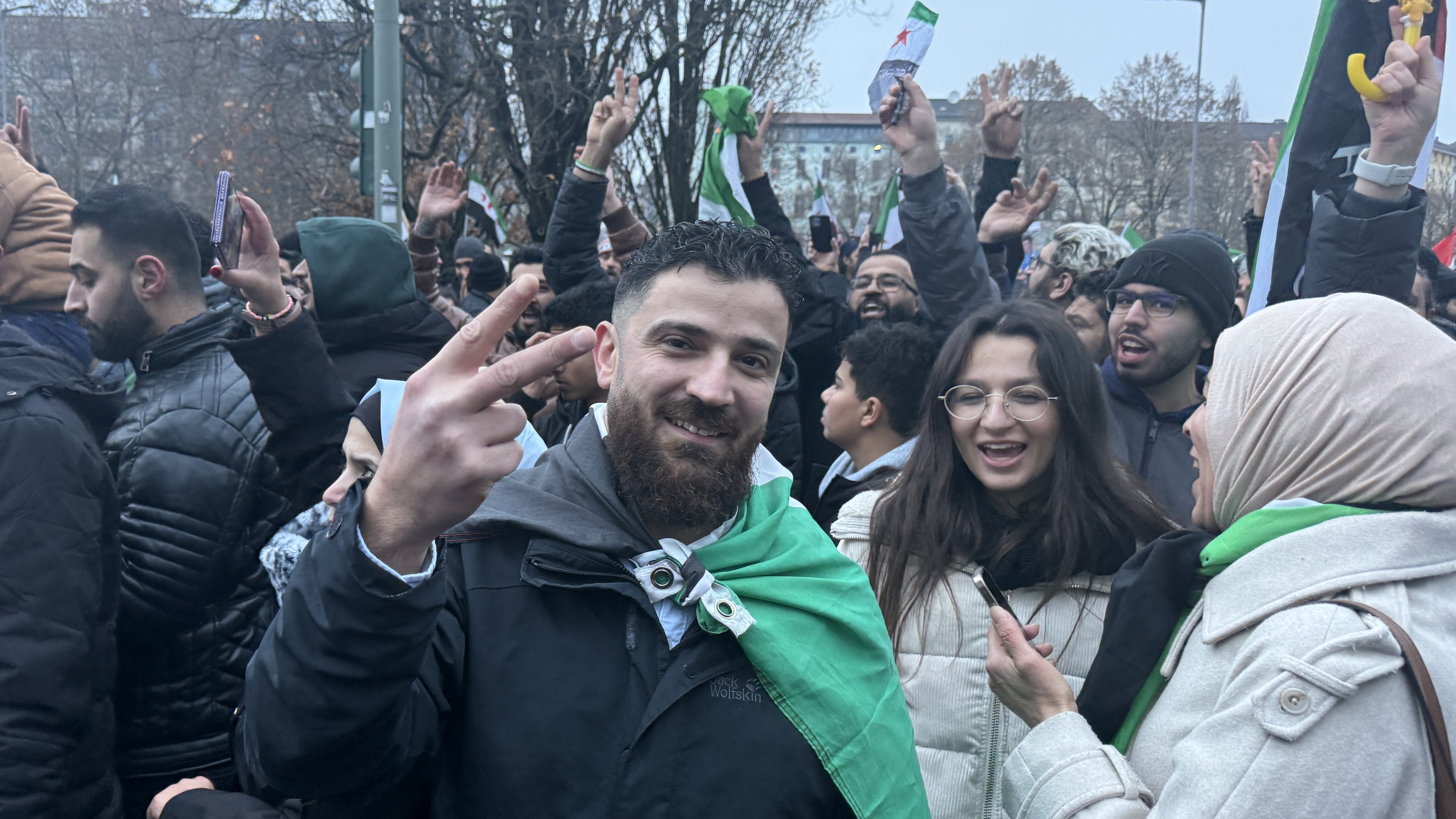 a man wears a flag in a protest.