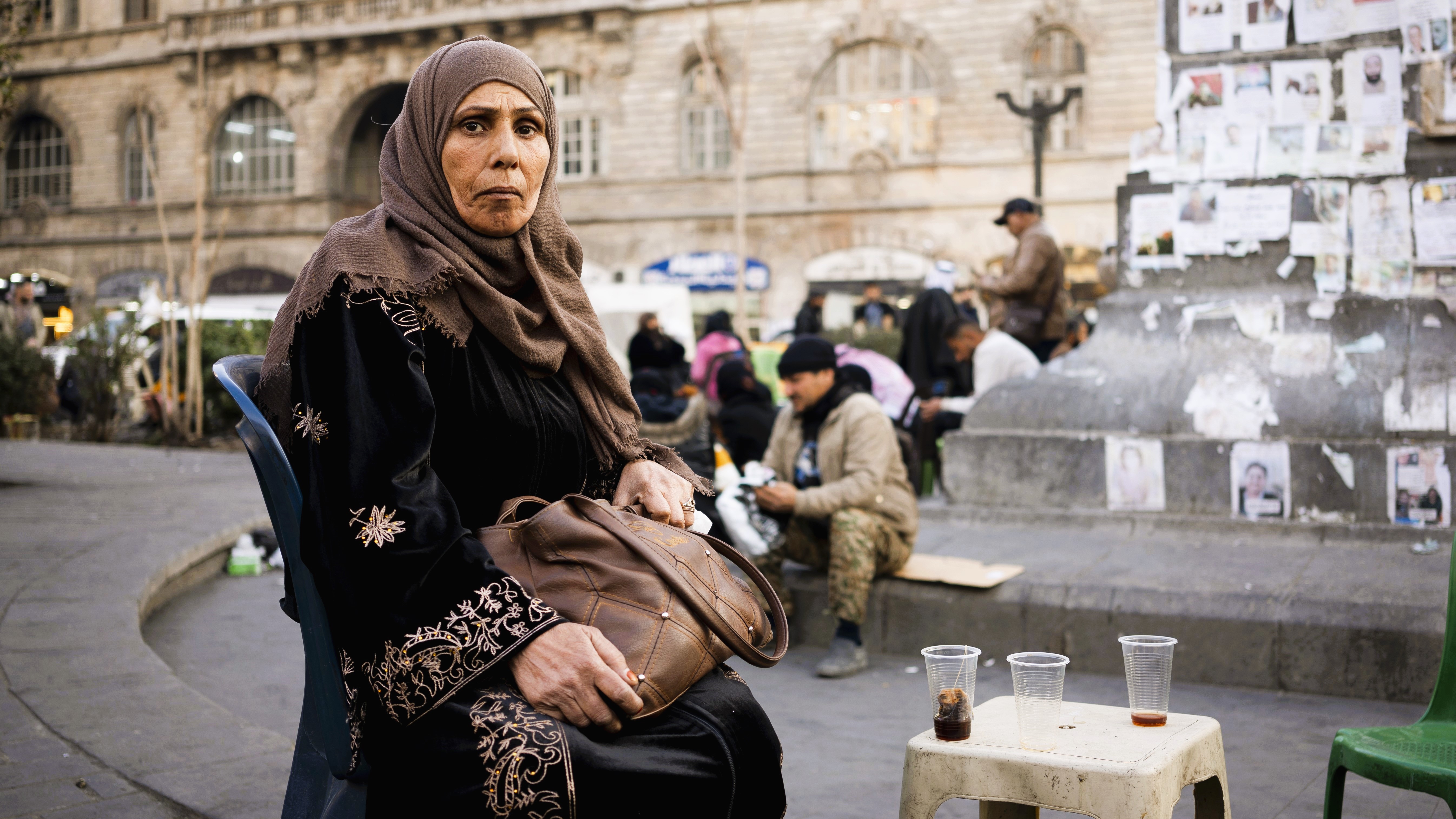 Samar Abd al-Majid sitzt auf einem Stuhl auf dem Märtyrer-Platz in Damaskus (Foto: Qantara | Andrea Backhaus)