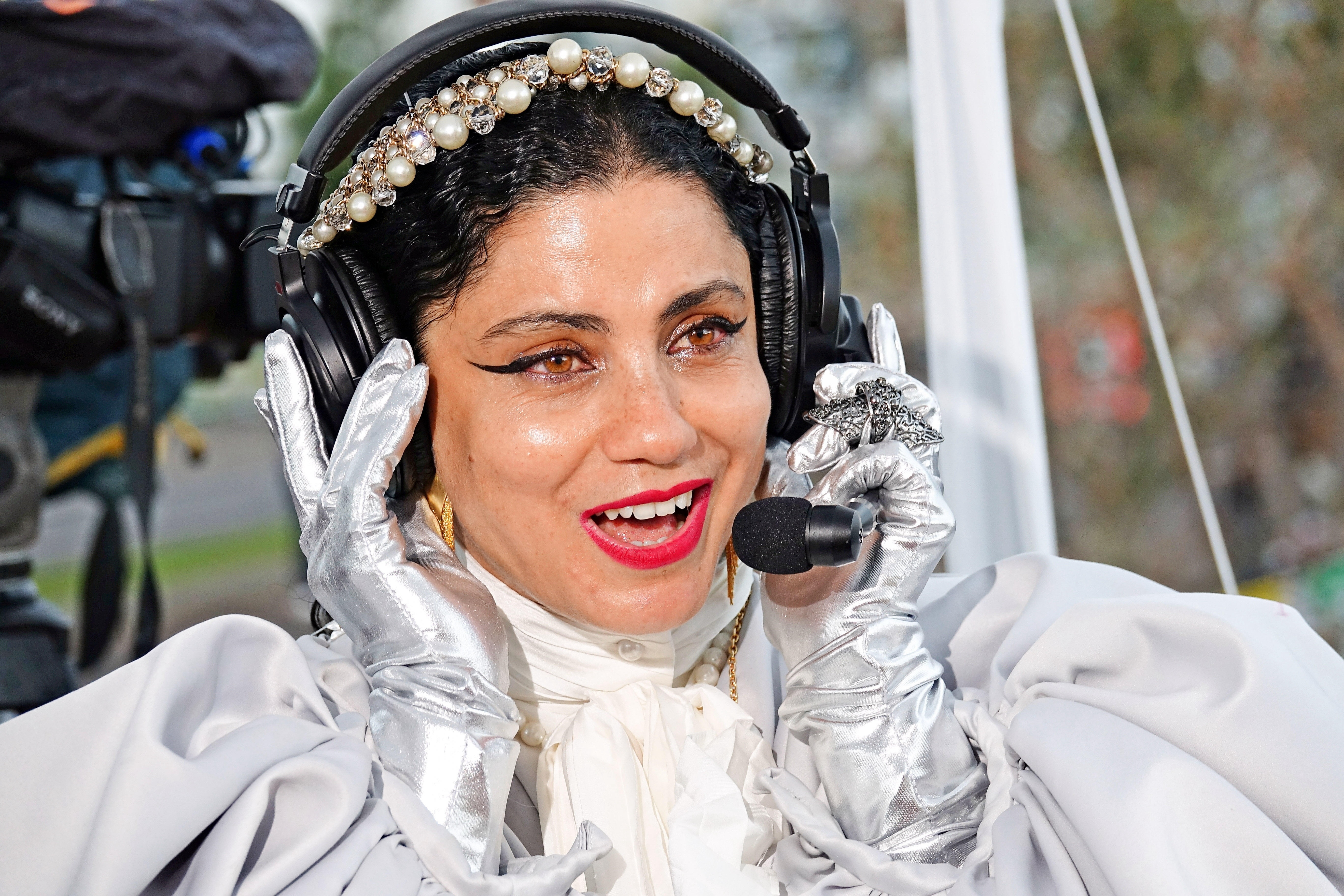 Emel Mathlouthi is wearing silver gloves and a headset while on the live broadcast of the Kurdish television Rudaw