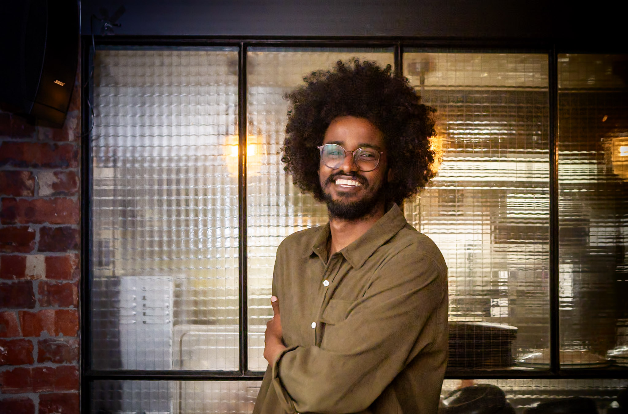 handsome black man smiles and holds his elbow