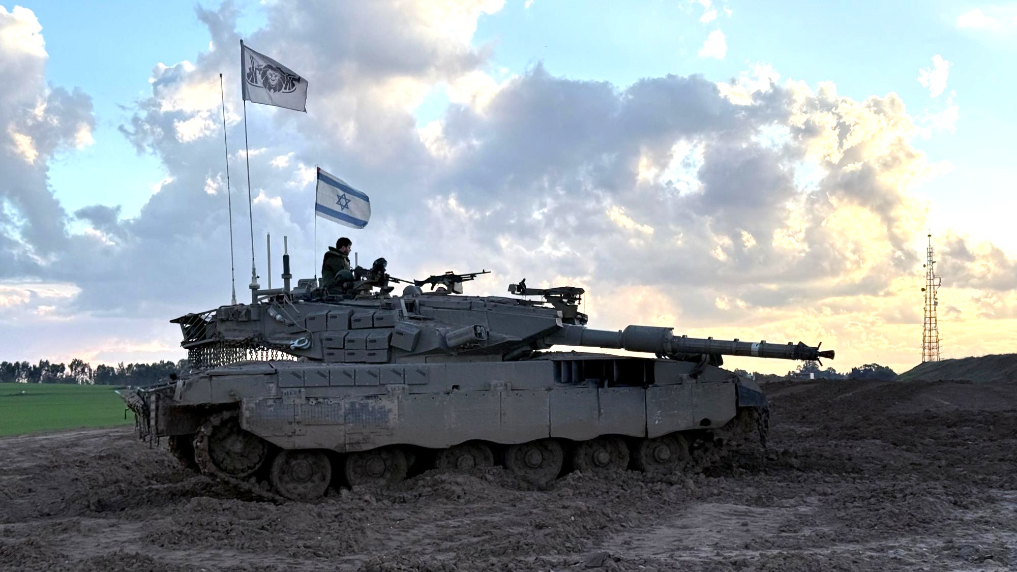 Israelischer Panzer an der Grenze zu Gaza, 24.1.2025. (Foto: Picture Alliance / CTK | P. Nemecek) Ein Panzer mit israelischer Flagge vor Wolken.