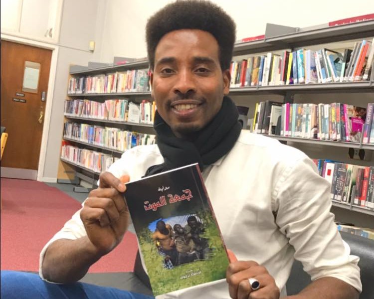 الحافظ ترجوك، كاتب رواية "جمعة الموت" عن دار رؤى للنشر. رجل يحمل كتاب في يديه تحت عنوان "جمعة الموت".