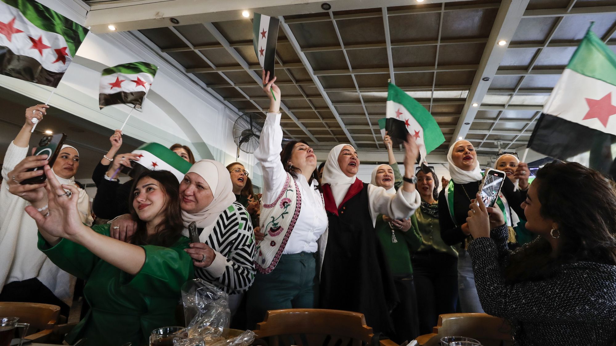 Frauen feiern mit den Flaggen des neuen Syriens.