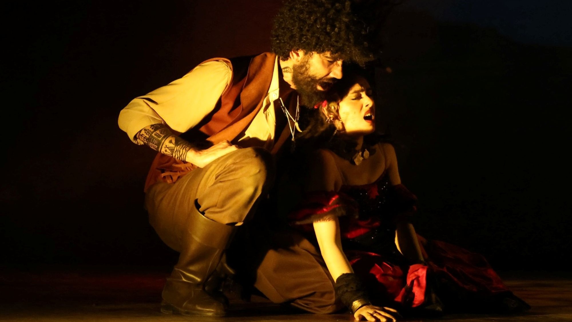 مشهد ضرب غارسيا لزوجته كارمن خلال عرض مسرح الطليعة. (Photo: Copyright for Eltaliaa Theater/facebook) رجل وامرأة يظهران وسط أضواء خافتة.