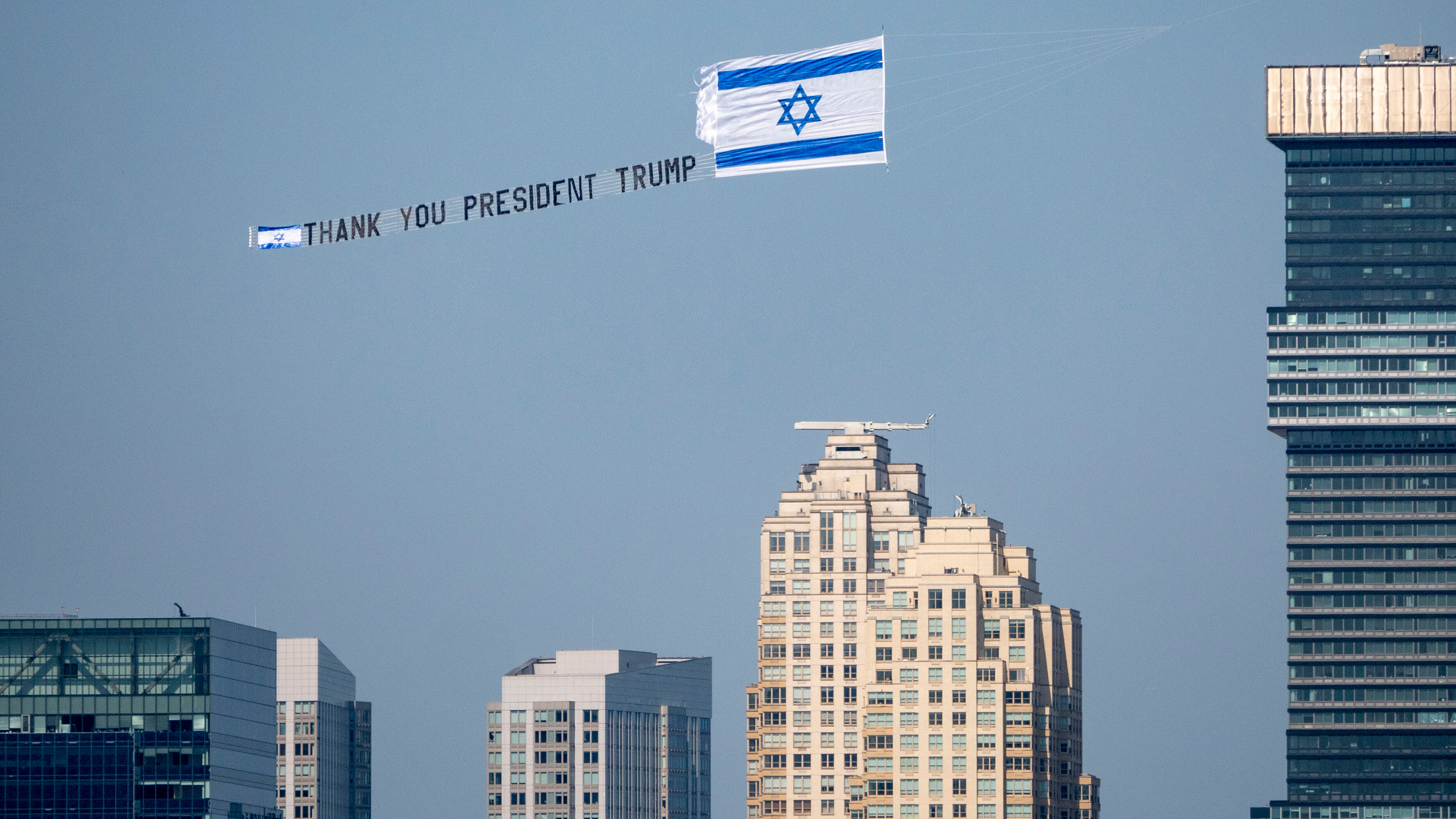 Eine Dankesbotschaft an Trump in New York, Juni 2025. (Photo: Picture Alliance/ZUMAPRESS.com | Milo Hess) Kleines Flugzeug, das die Botschaft „Danke, Präsident Trump“ den Hudson River über Jersey City hinauffliegt.