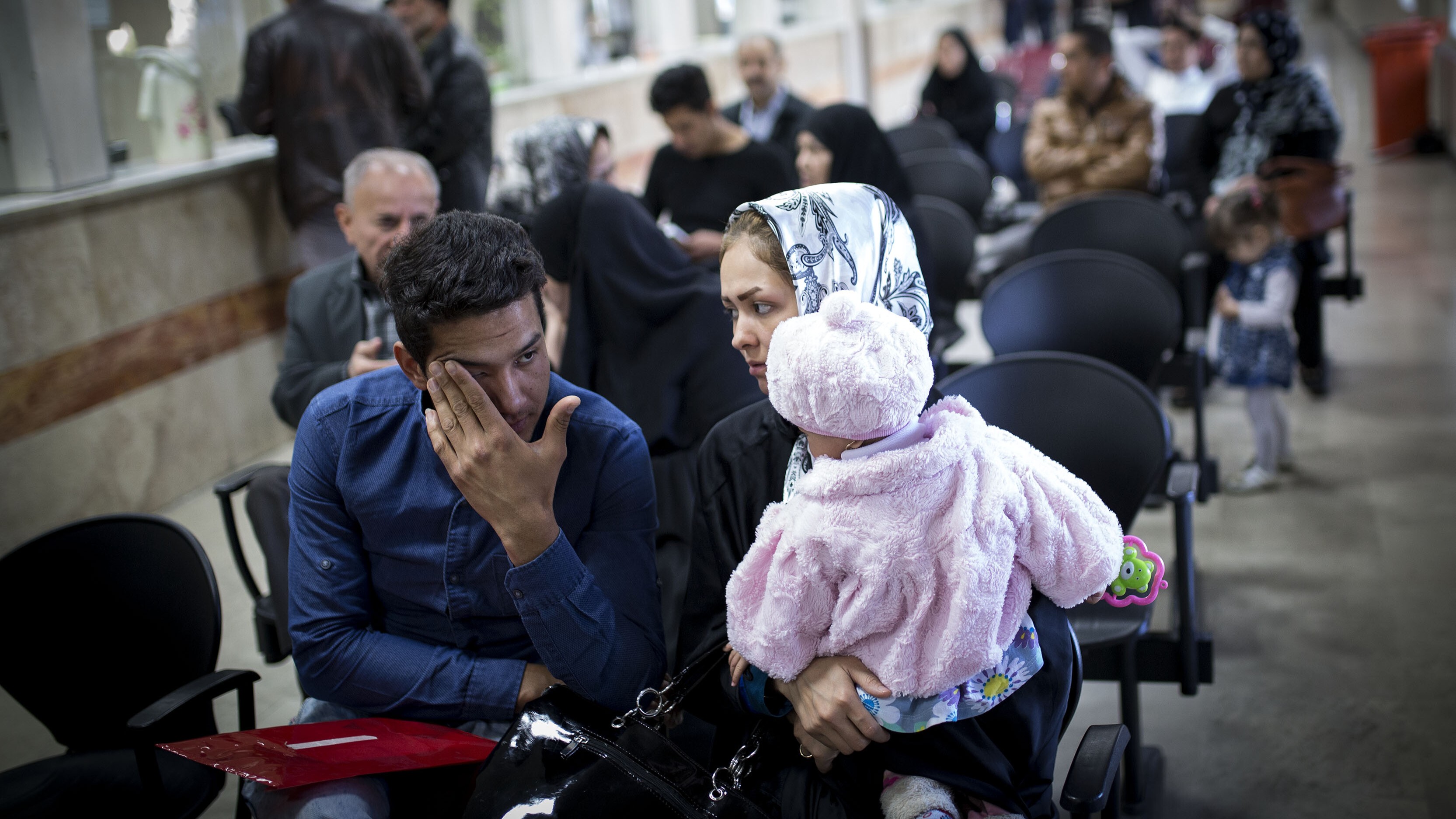 Geflüchtete aus Afghanistan im Iran (picture alliance / ZUMAPRESS.com | Ahmad Halabisaz) Eine afghanische Familie wartet in einer Behörde (picture alliance / ZUMAPRESS.com | Ahmad Halabisaz))
