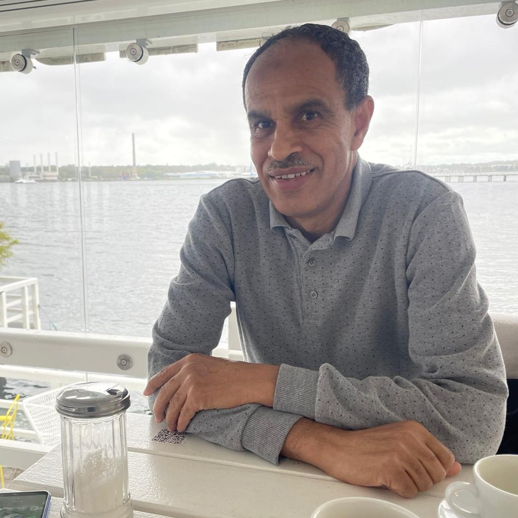 Sadik Rddad the author of ''dis-orienting the Maghreb''. (Private) A man is sitting in a table and a view of water in the background.