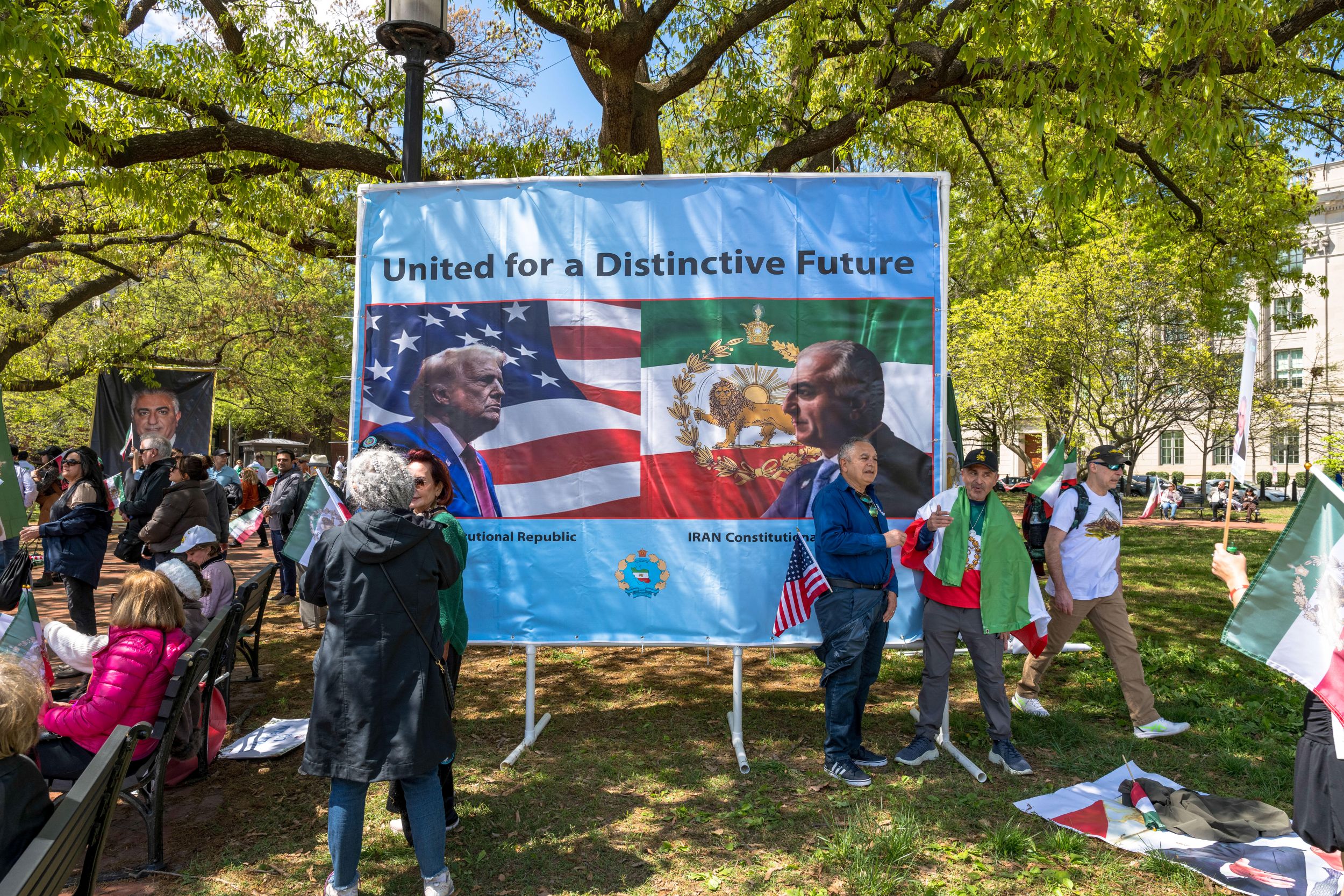A billboard on a green lawn. Text reads "United for a Distinctive Future". Underneath are the profiles of Trump and Reza Pahlavi superimposed over their respective national flags.