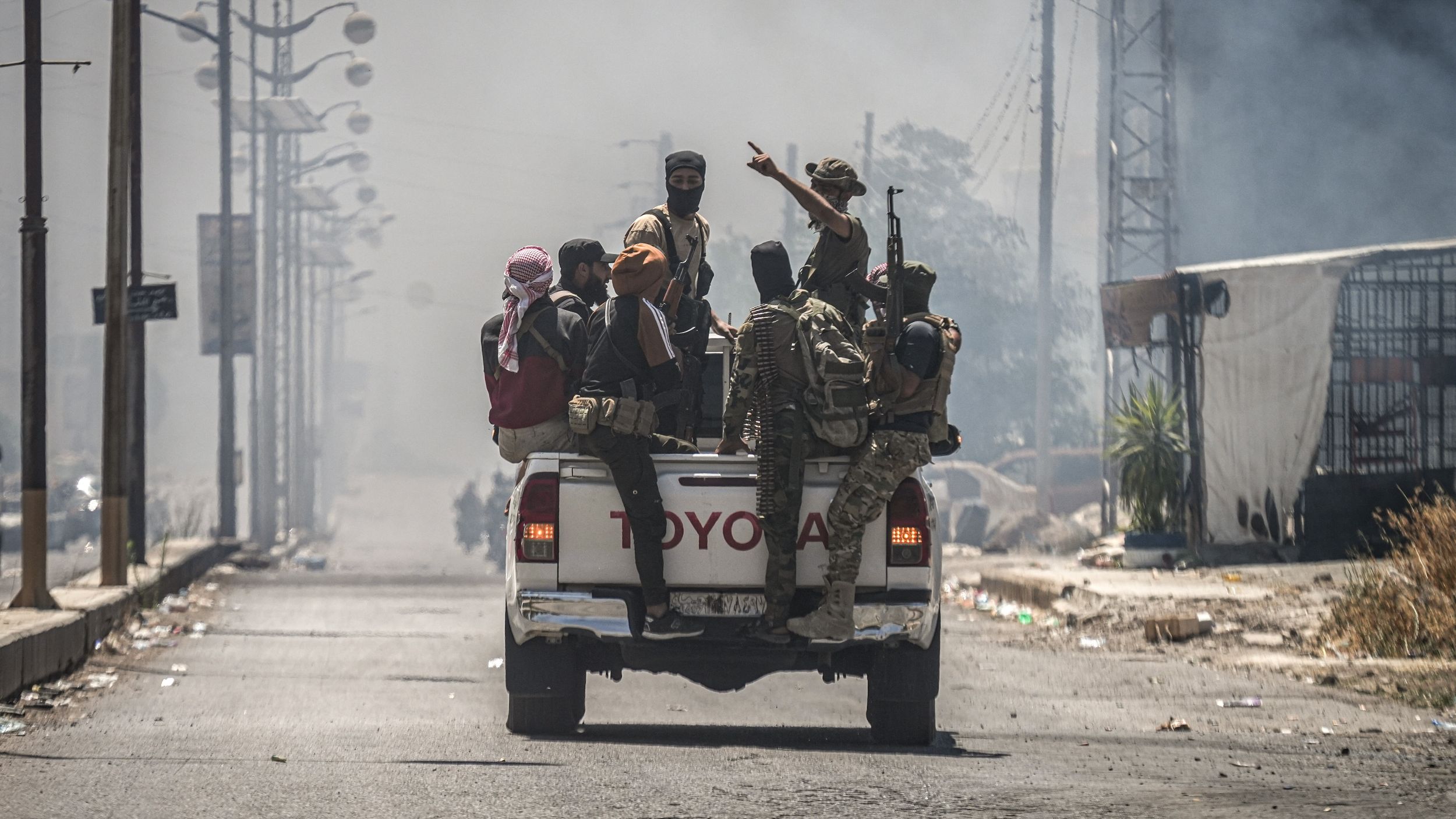 Fighters in As-Suwayda, 19 July 2025. (Photo: picture alliance/dpa | M. Atrash) A Toyota truck carrying a group of armed and masked fighters.