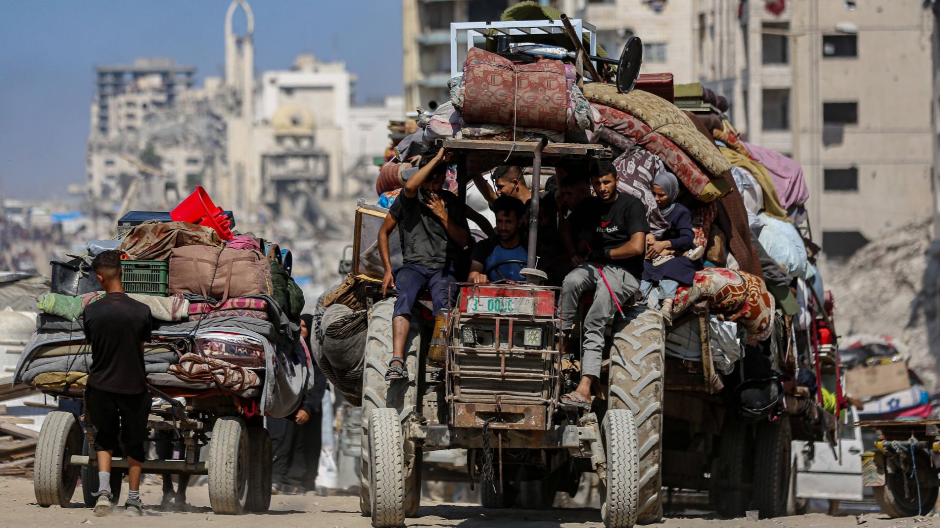 فلسطينيون نازحون ينقلون متعلقاتهم على متن جرار أثناء فرارهم من الهجوم الإسرائيلي على مدينة غزة. (Photo: Picture Alliance / SIPA | Omar Ashtawy)