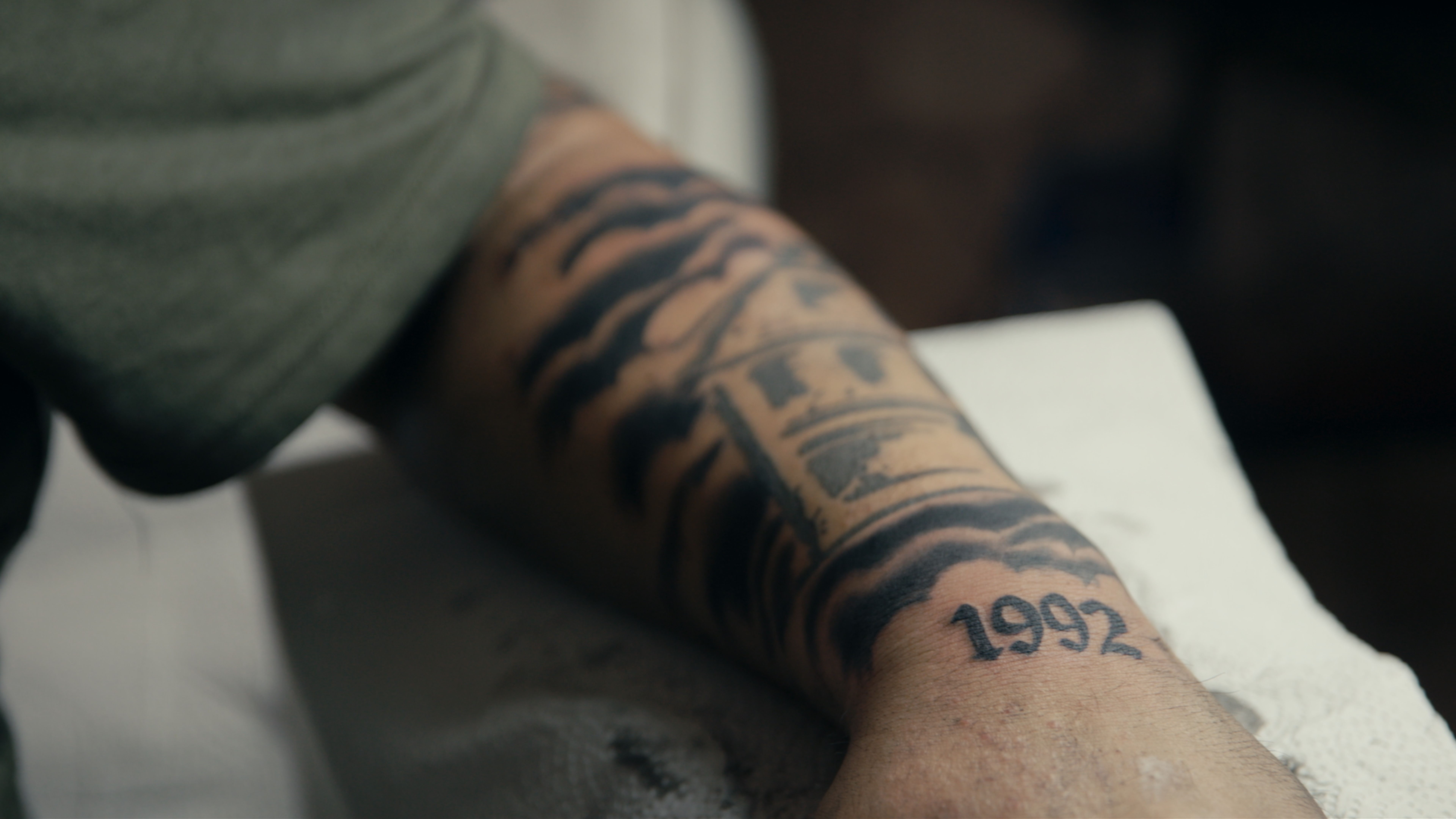Ein Unterarm eines jungen Mannes mit einem Tattoo