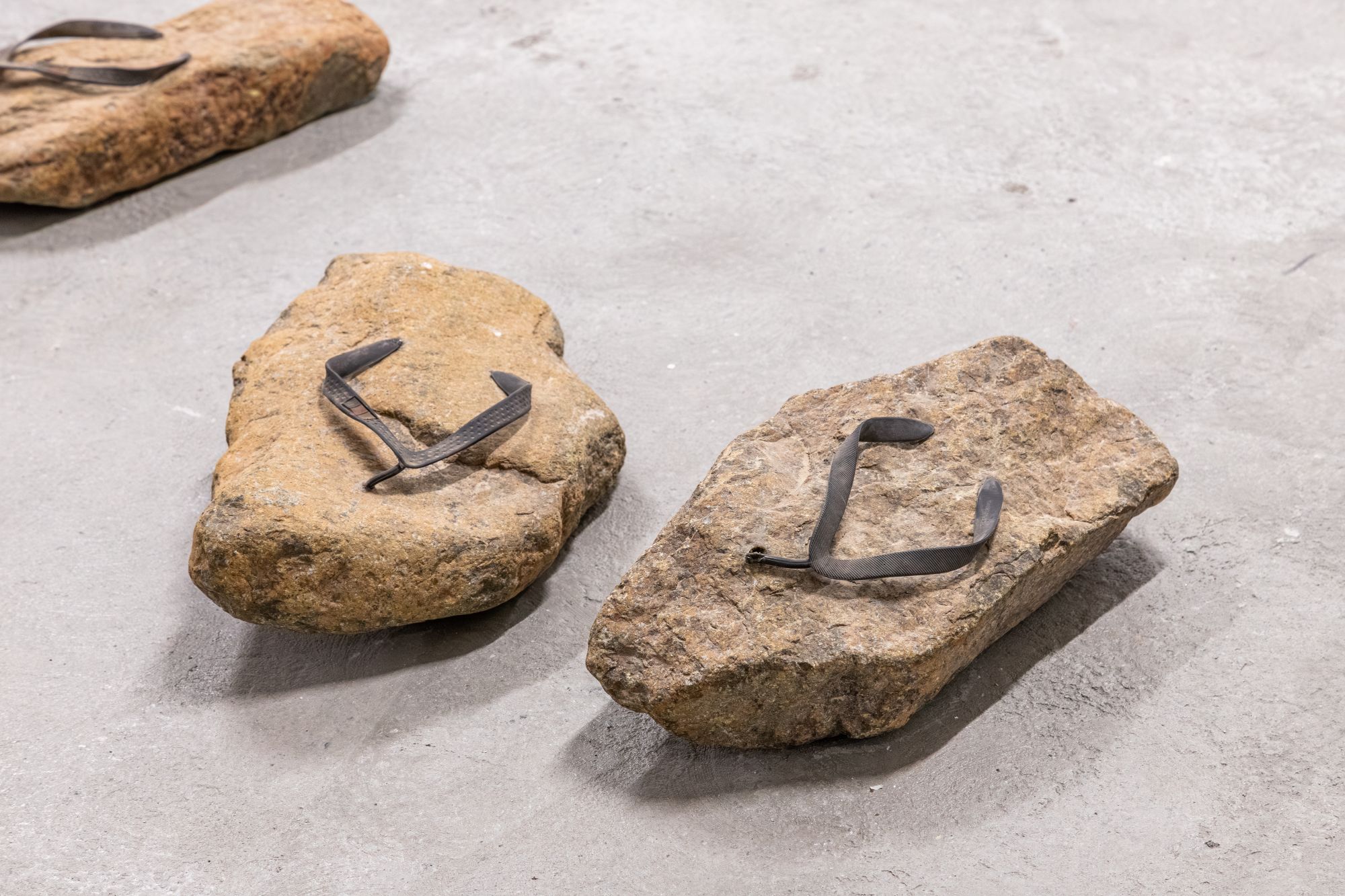 "Stone Slippers" (2023) by Abdullah Al Saadi. (Photo: IKSV | Sahir Ugur Eren) Two stones with rubber straps so that they resemble flip-flops.
