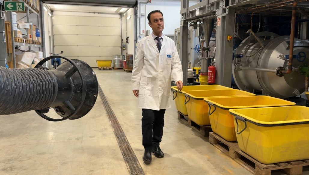A man walks past equipment through a hall.