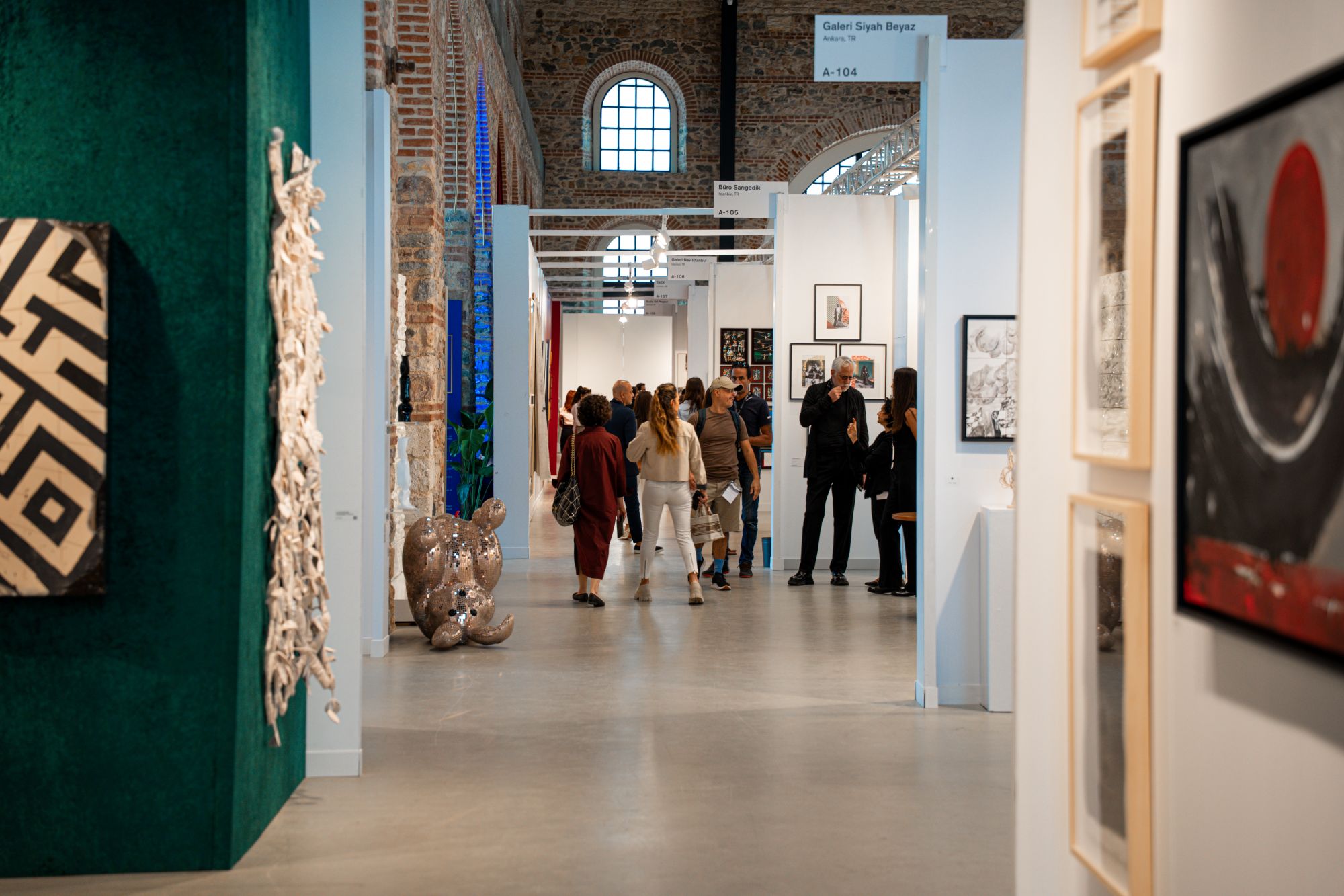 Contemporary Istanbul 2025. (Photo: courtesy of Contemporary Istanbul) A corridor with paintings and sculptures laid out across the room.