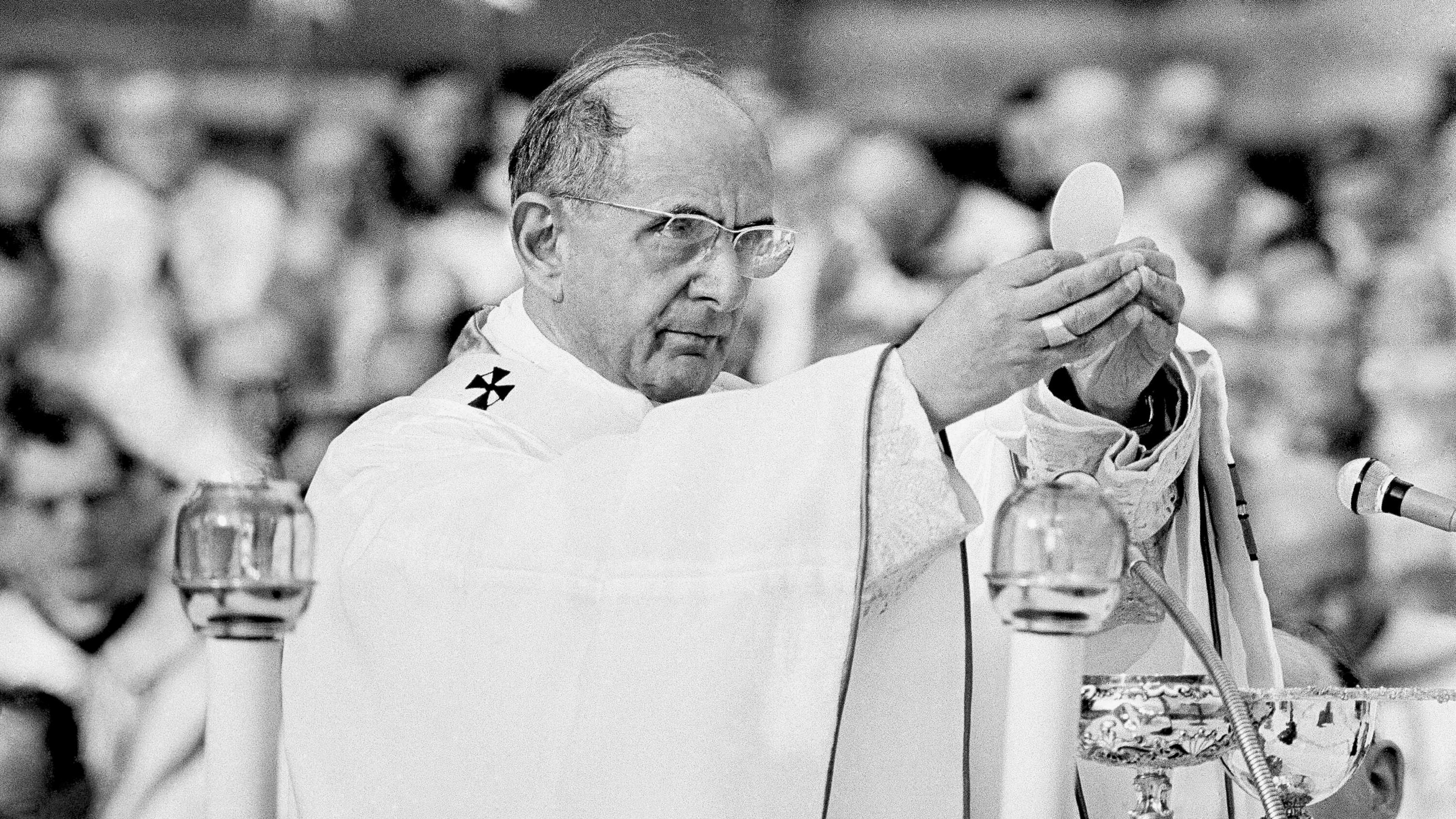 Pope Paul VI at the Second Vatican Council, 1965. (Photo: picture alliance / AP | Uncredited) A man in a white robe holds up a communion wafer and breaks it.