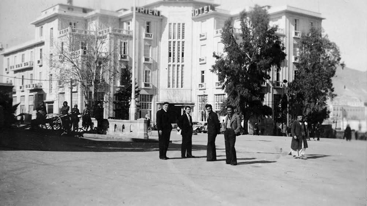 Schwarz-weiß Bild: Eine Gruppe Männer vor einem urbanen Gebäude.